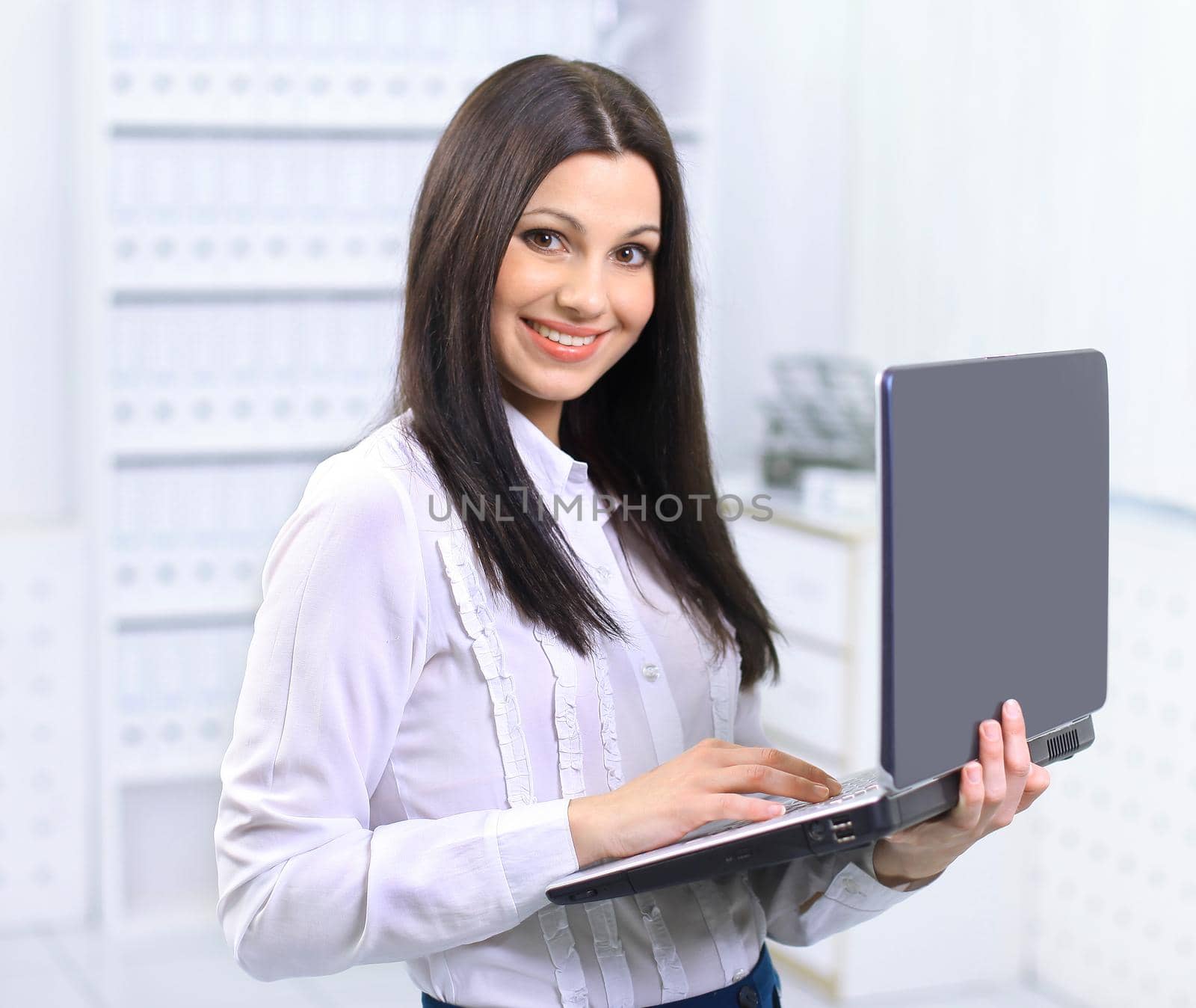 The beautiful business woman with the computer at office