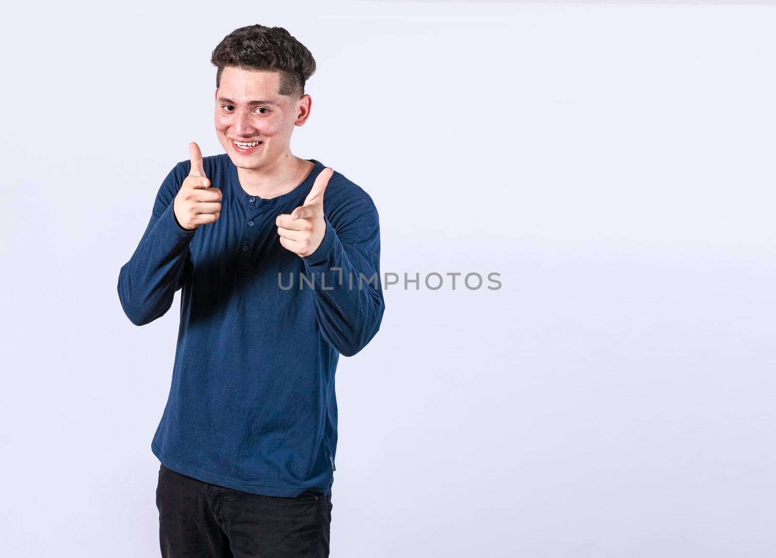 young man with thumbs up on white background, positive boy with thumbs up doing ok, Smiling man showing ok gesture looking at camera