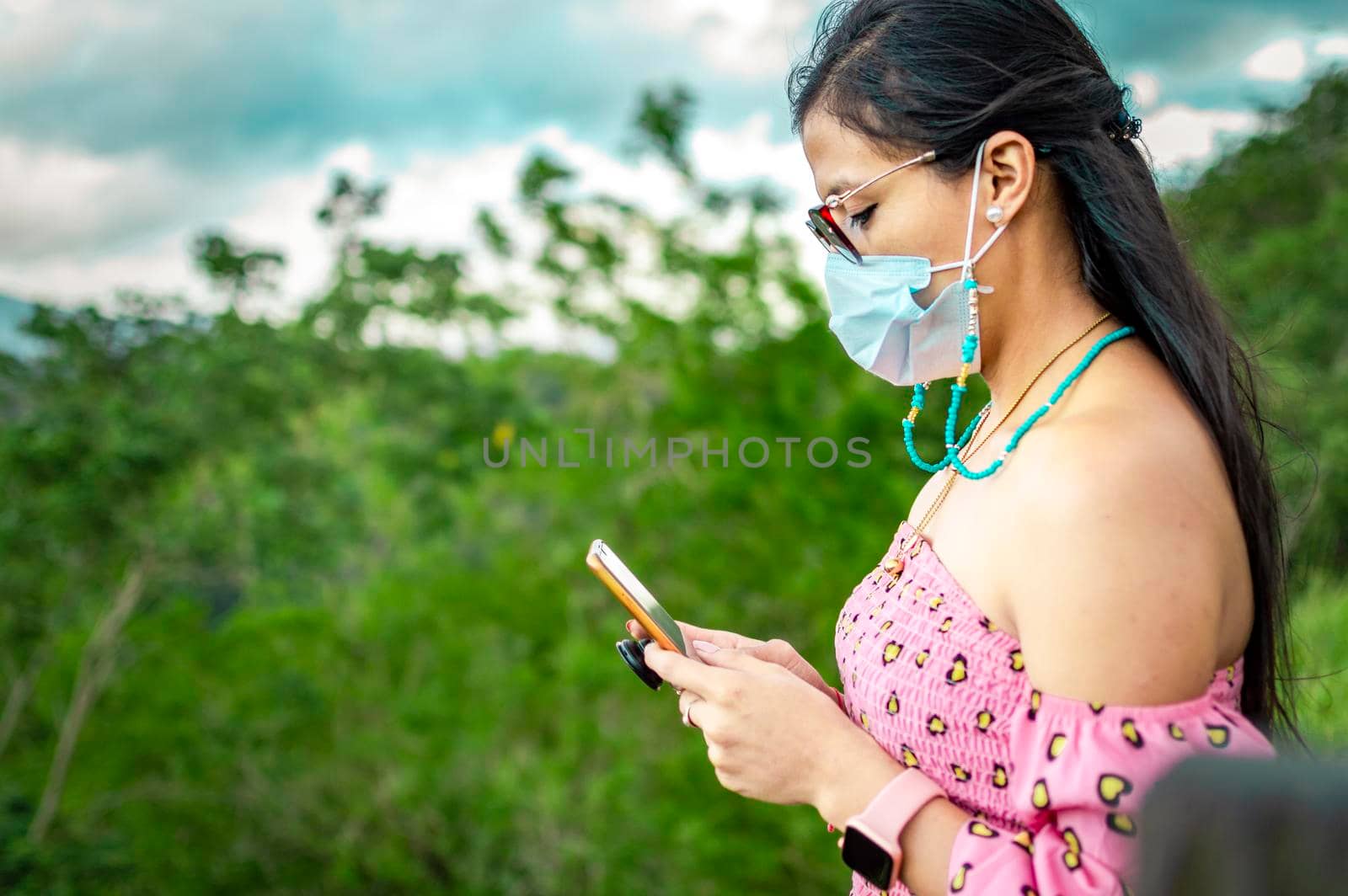 Latin woman checking her cell phone, pretty girl in glasses checking her cell phone