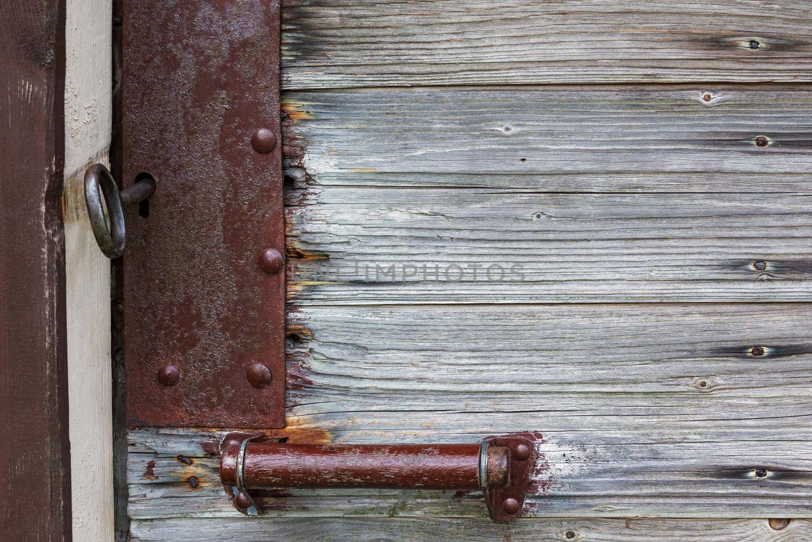 Old brown rustic door open with rusty lock, key and keyhole by Lincikas