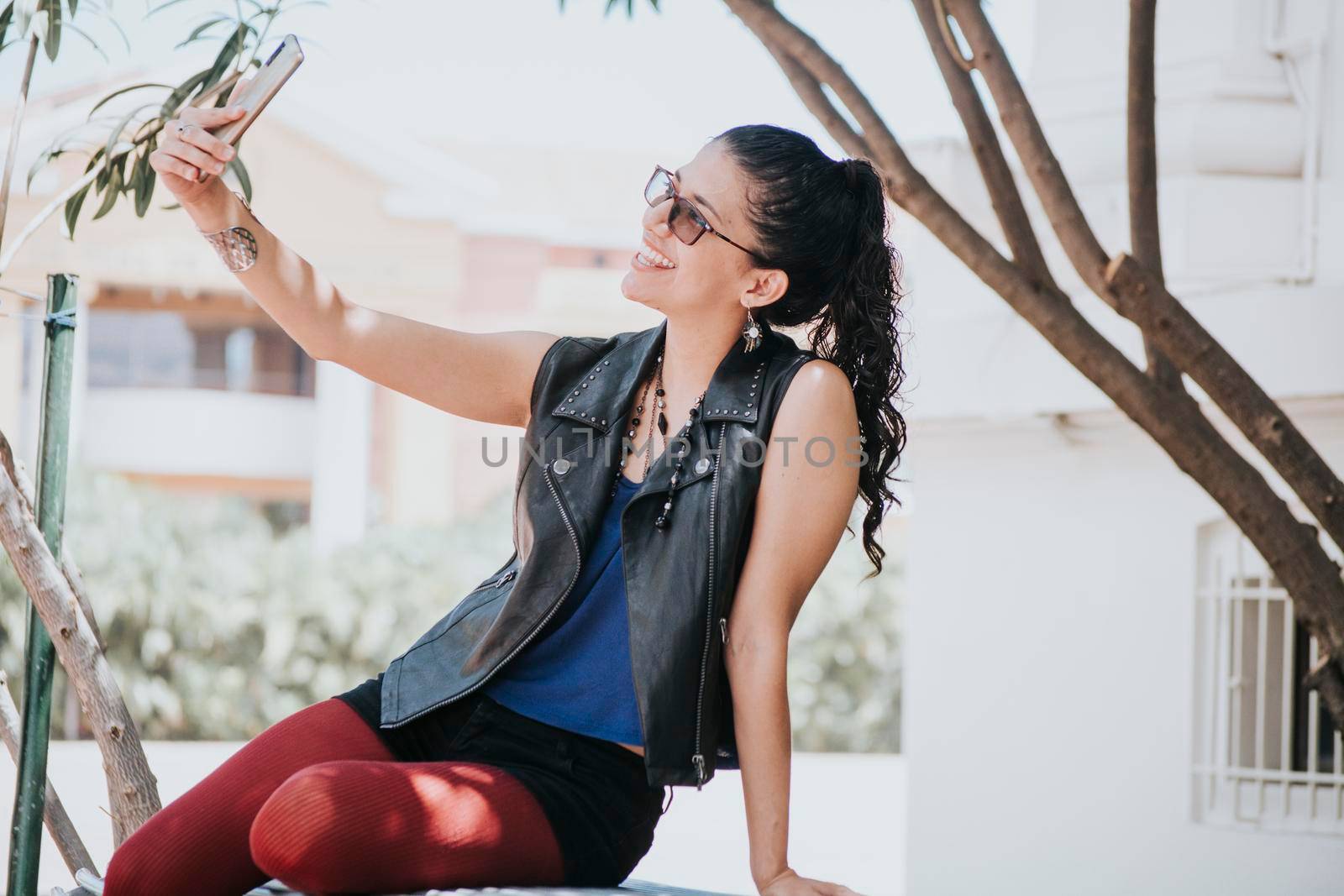 Close-up of a girl taking a selfie, urban girl taking a selfie outdoors, lifestyle woman smiling and taking a selfie by isaiphoto