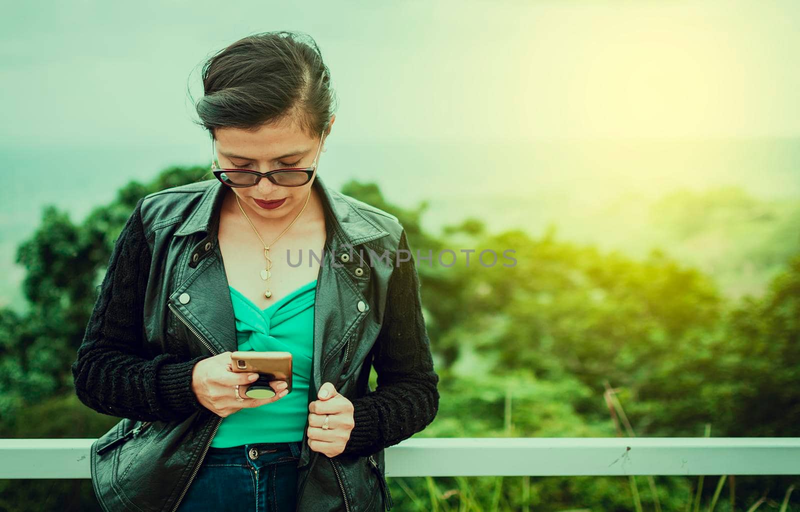 Latin woman checking her cell phone, pretty girl in glasses checking her cell phone