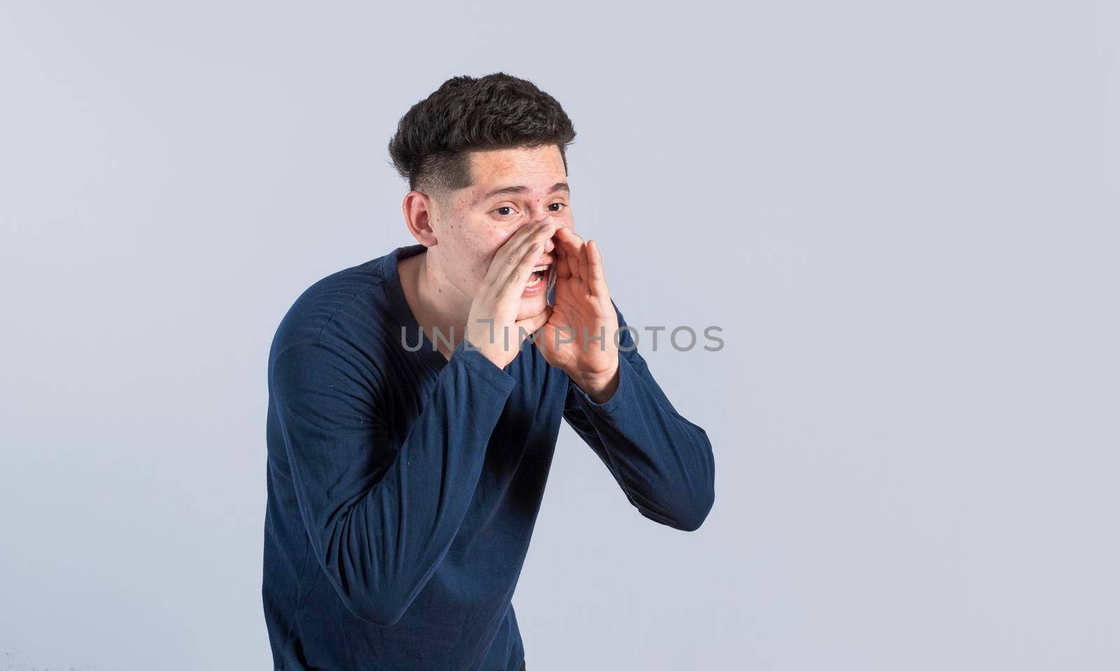 A person announcing and yelling, Handsome man shouting an announcement, isolated.  concept of a guy yelling an announcement by isaiphoto