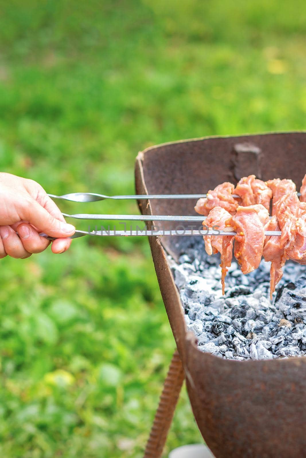 Hands of man prepares barbecue meat by okskukuruza