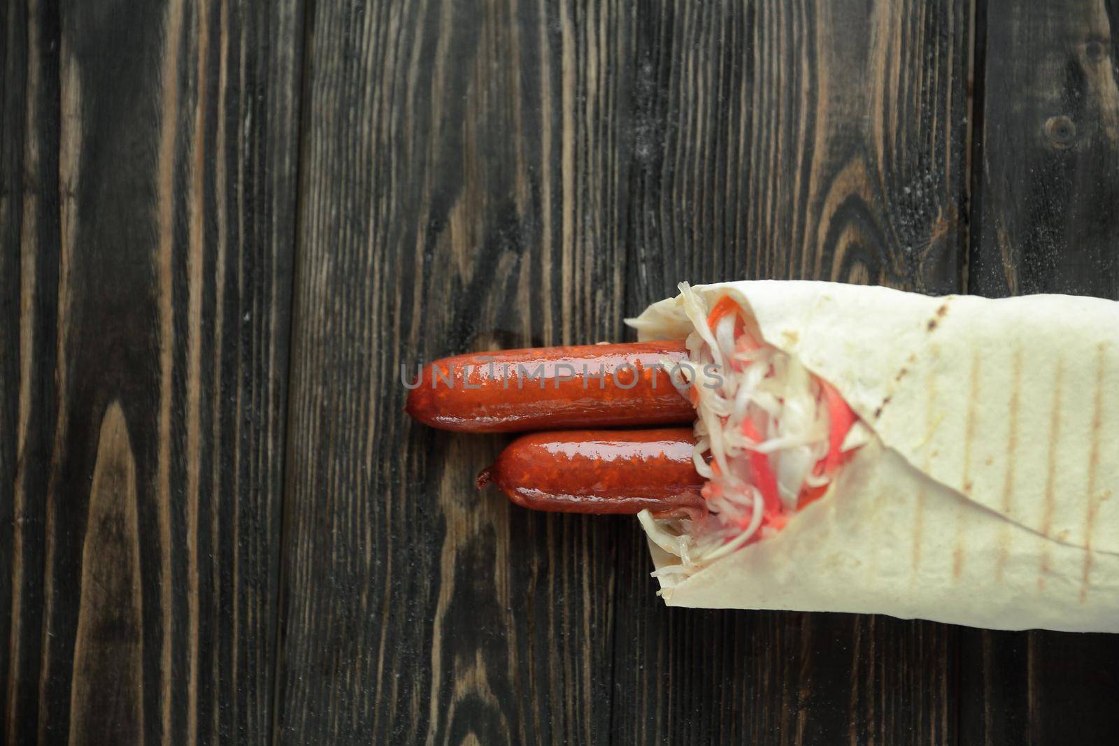 tender sausages in pita bread on wooden background.photo with copy space.