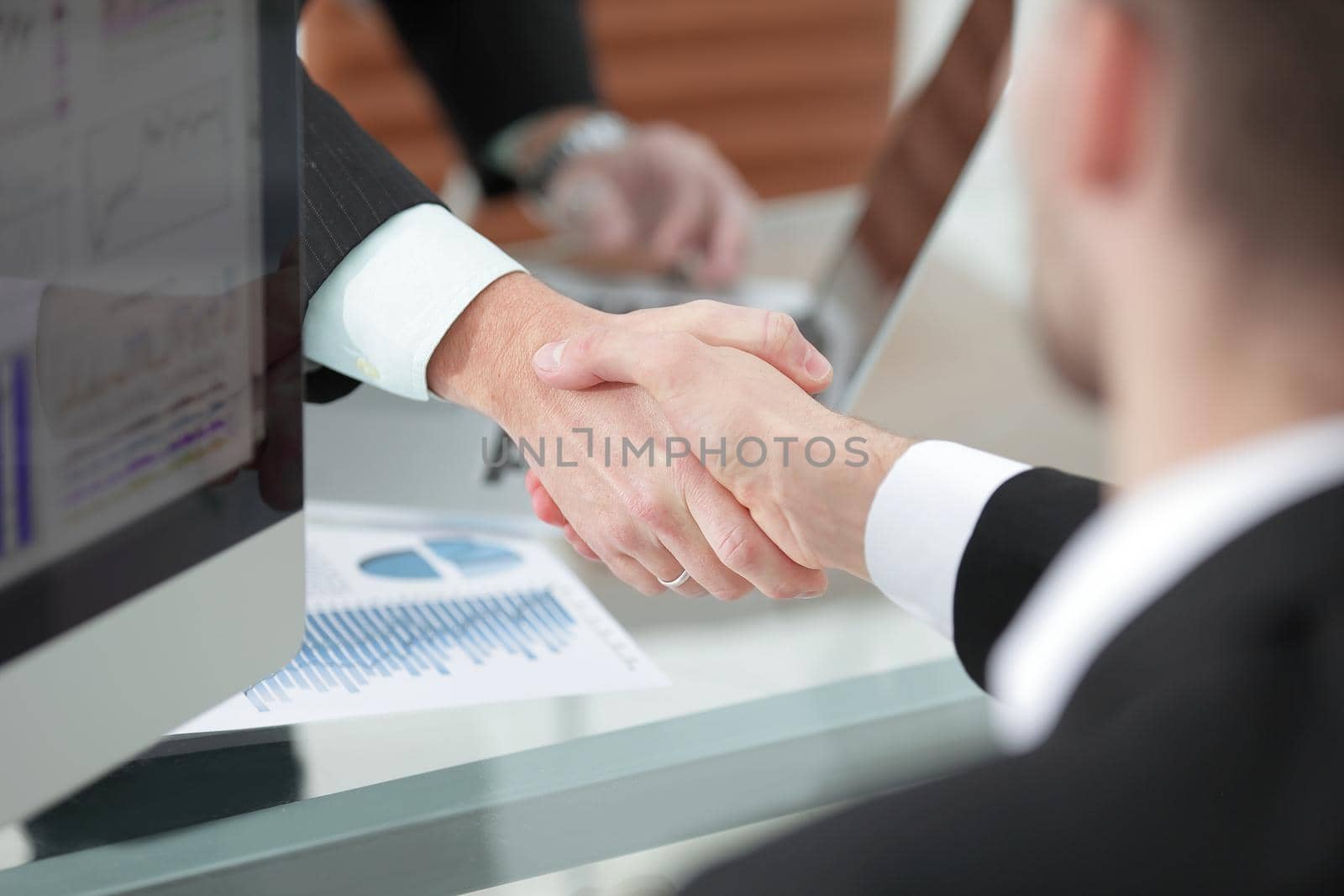 close up. handshake of business partners above the Desk.concept of partnership