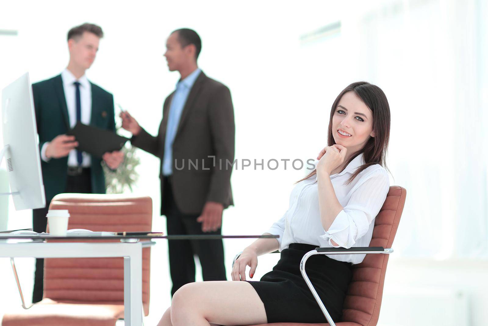 successful business woman sitting at Desk in her office by SmartPhotoLab