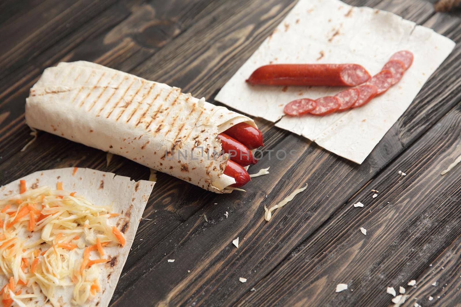 sausages in pita bread on wooden background.