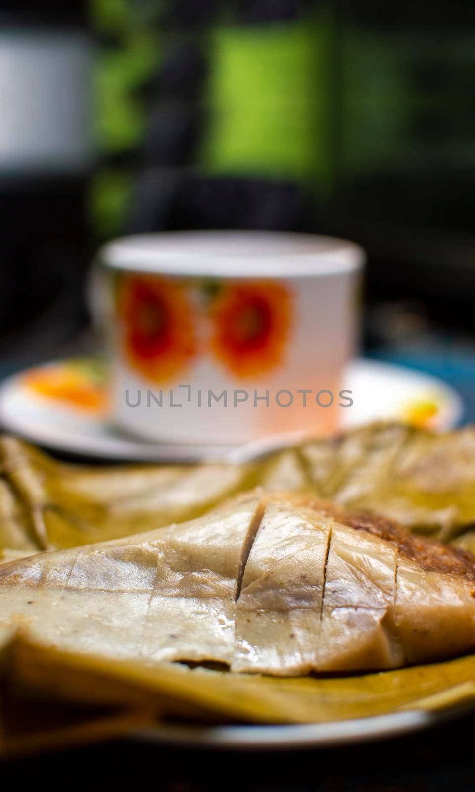 Stuffed tamale served on wooden table, stuffed tamale on banana leaf served on wooden table, typical nicaragua food