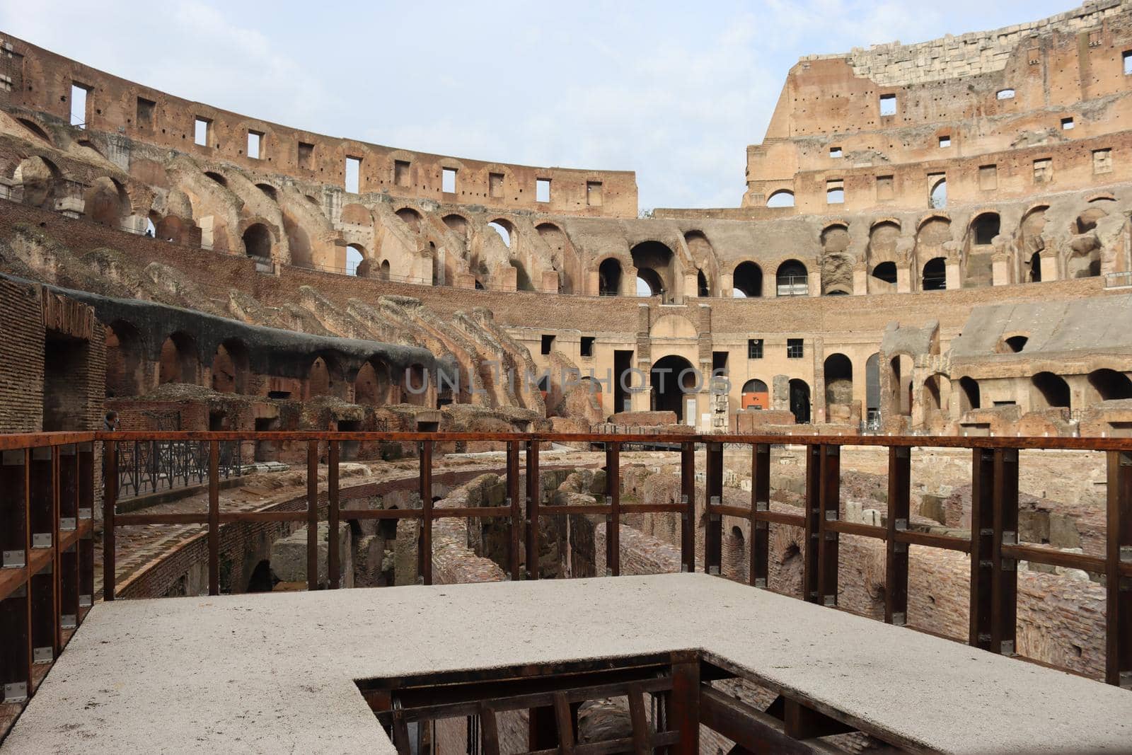 ROME, ITALY - February 05, 2022: Panoramic view around the Colosseum in city of Rome, Italy. Cold and gray sky in the background. Macro photography of the green parks with the old buildings.