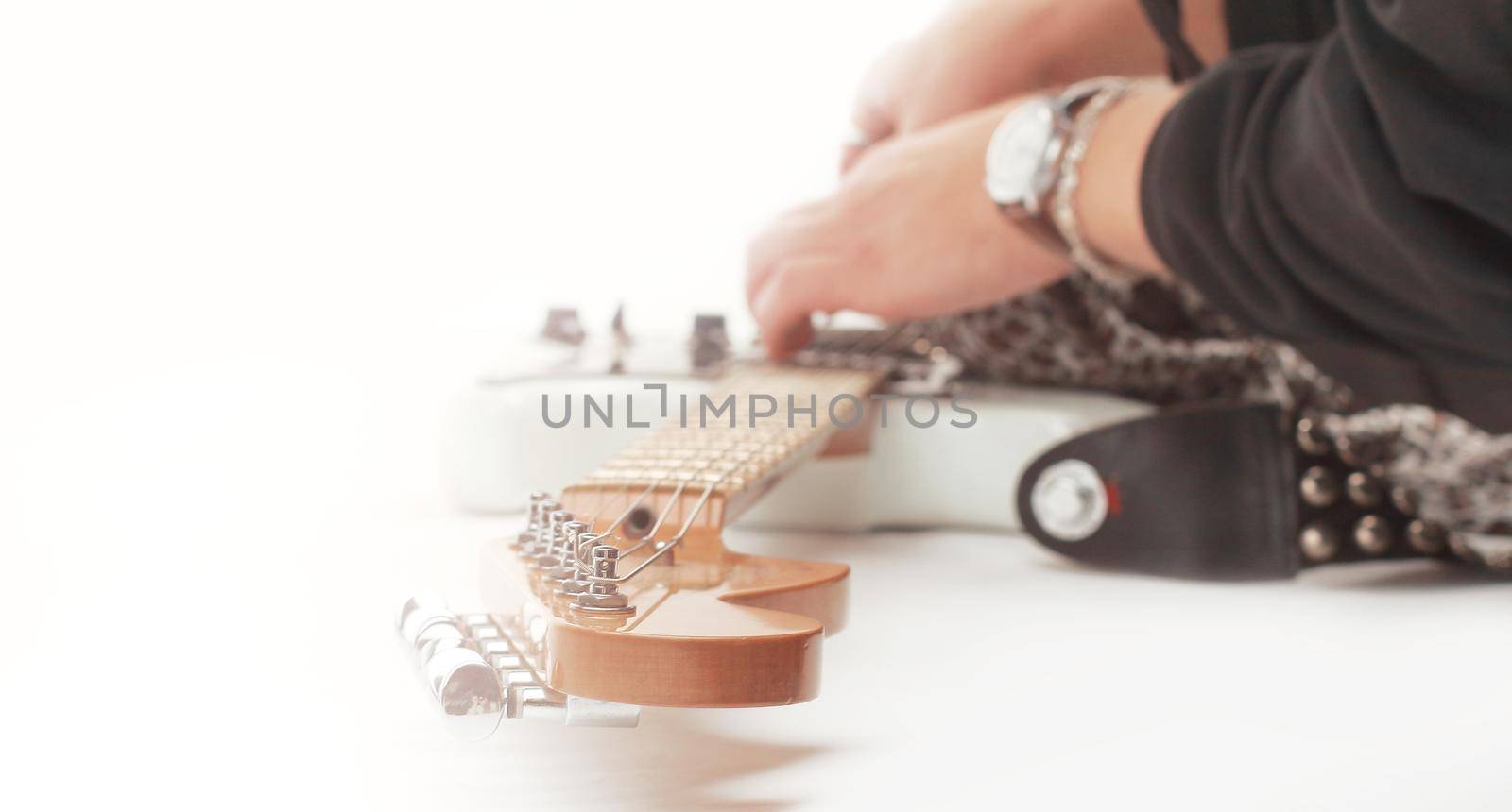closeup of a musician by connecting the cord to the guitar .isolated on a white background.photo with copy space