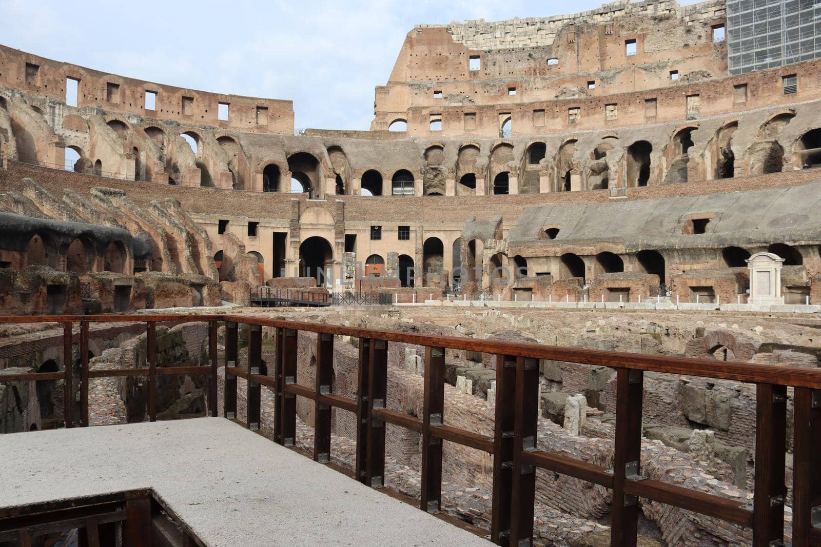 ROME, ITALY - February 05, 2022: Panoramic view around the Colosseum in city of Rome, Italy. Cold and gray sky in the background. Macro photography of the green parks with the old buildings.