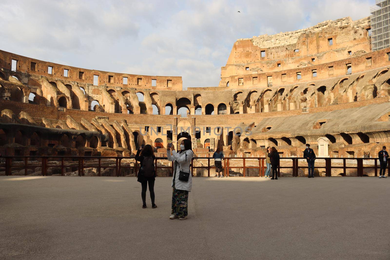 ROME, ITALY - February 05, 2022: Panoramic view around the Colosseum in city of Rome, Italy. Cold and gray sky in the background. Macro photography of the green parks with the old buildings.