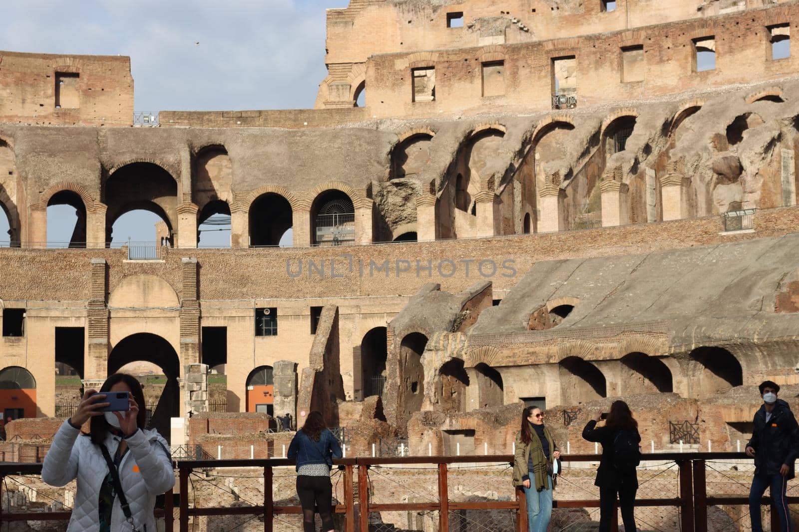 ROME, ITALY - February 05, 2022: Panoramic view around the Colosseum in city of Rome, Italy. Cold and gray sky in the background. Macro photography of the green parks with the old buildings.