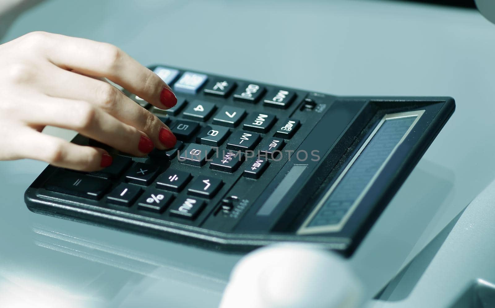 .closeup.business woman using a calculator at the workplace. by SmartPhotoLab