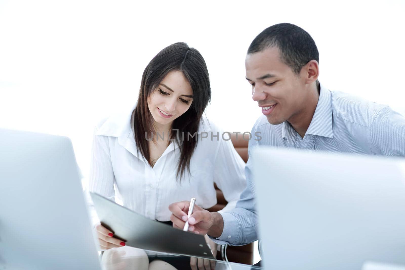 employees discussing financial documents sitting at a Desk by SmartPhotoLab
