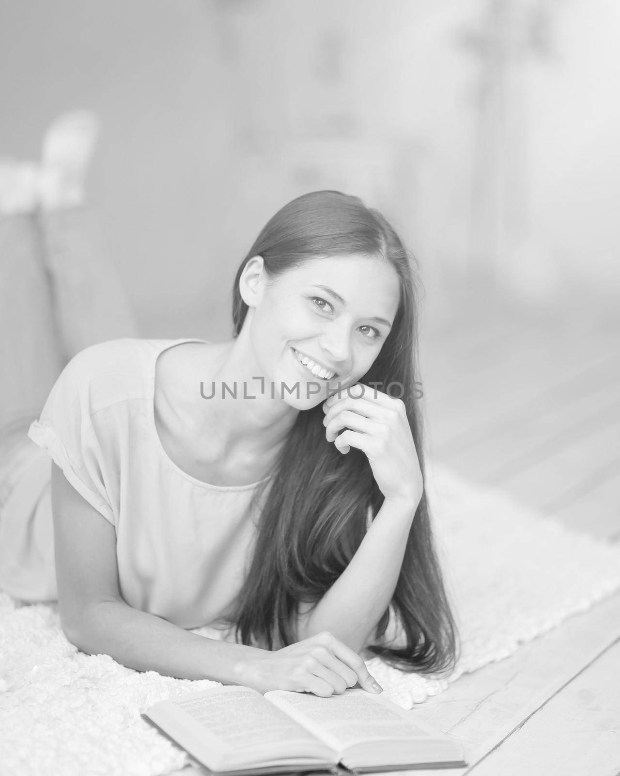 close up.young woman reading a book lying on the floor in the living .