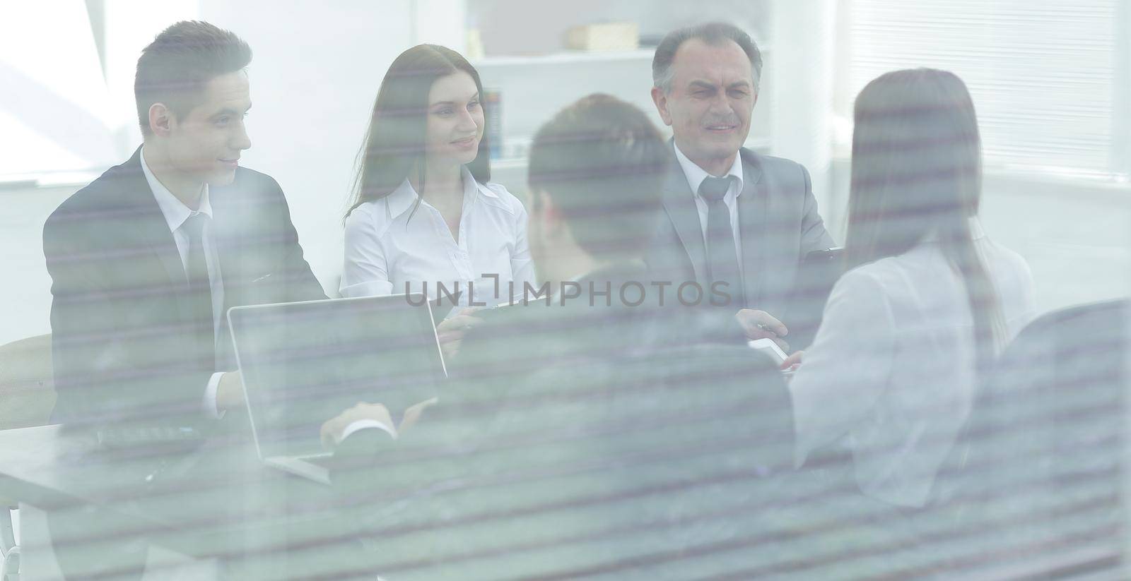 from behind the glass.startup business people group working everyday job at modern office.