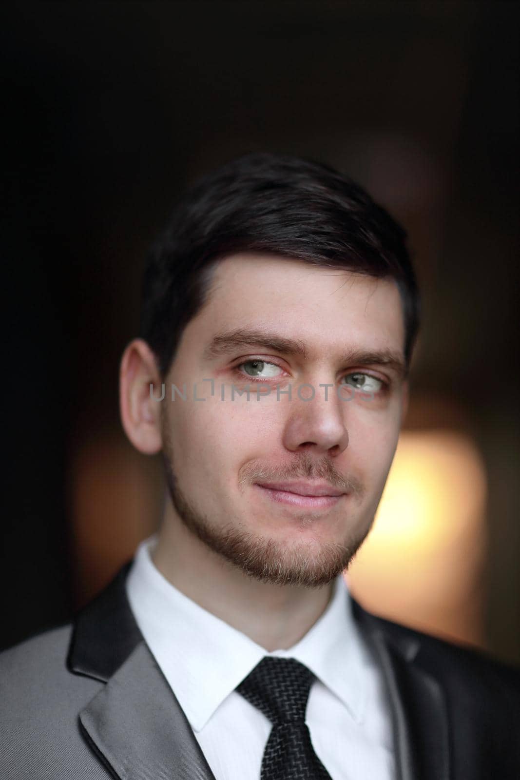 close up.portrait of a beautiful businessman on a dark background by SmartPhotoLab