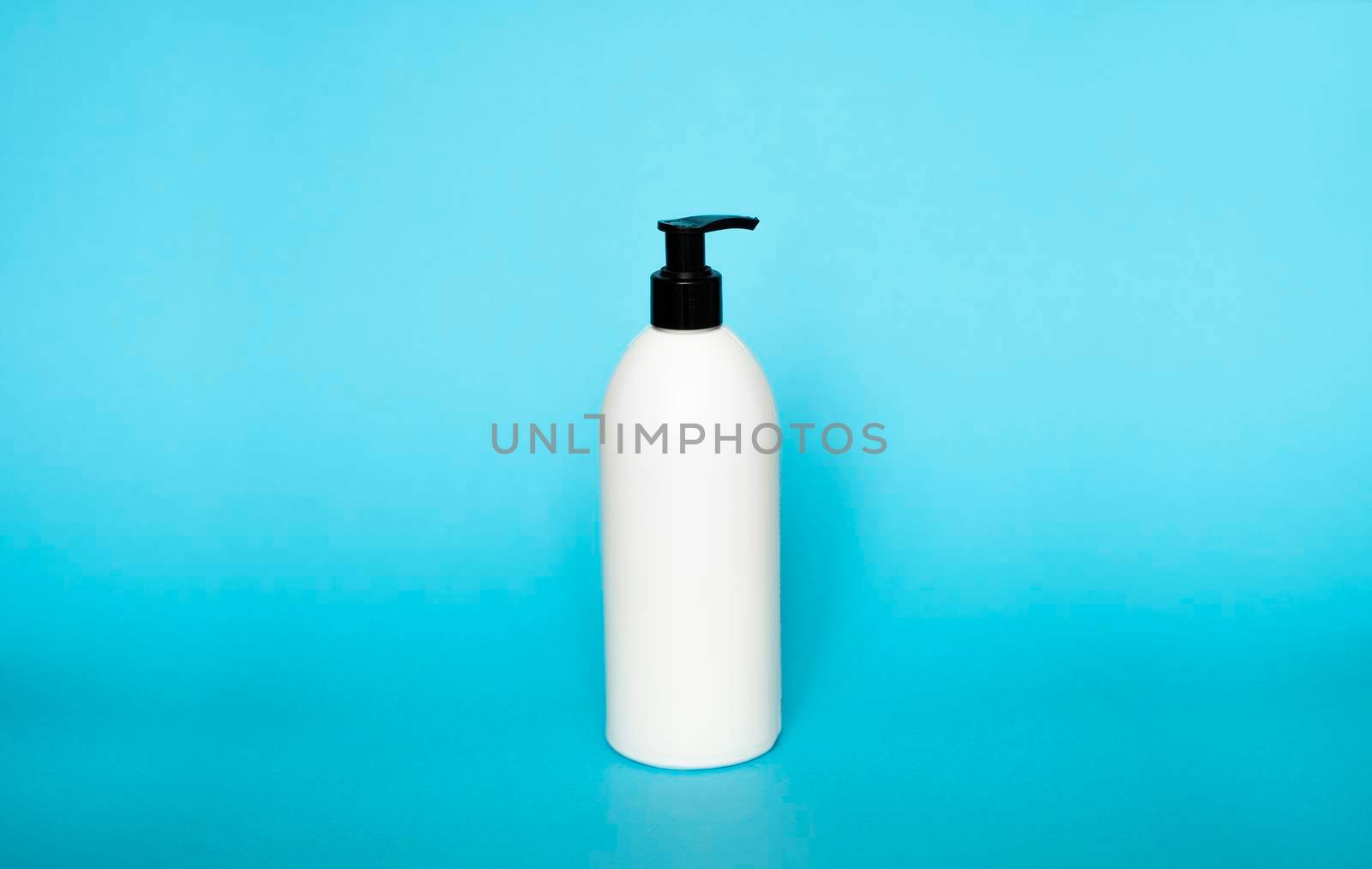 White plastic bottle with shampoo, conditioner or shower gel on a blue background. Mock up template for design