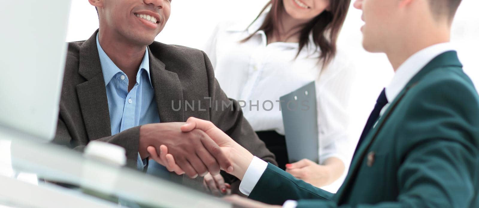 handshake of business partners sitting at a table Desk in the office