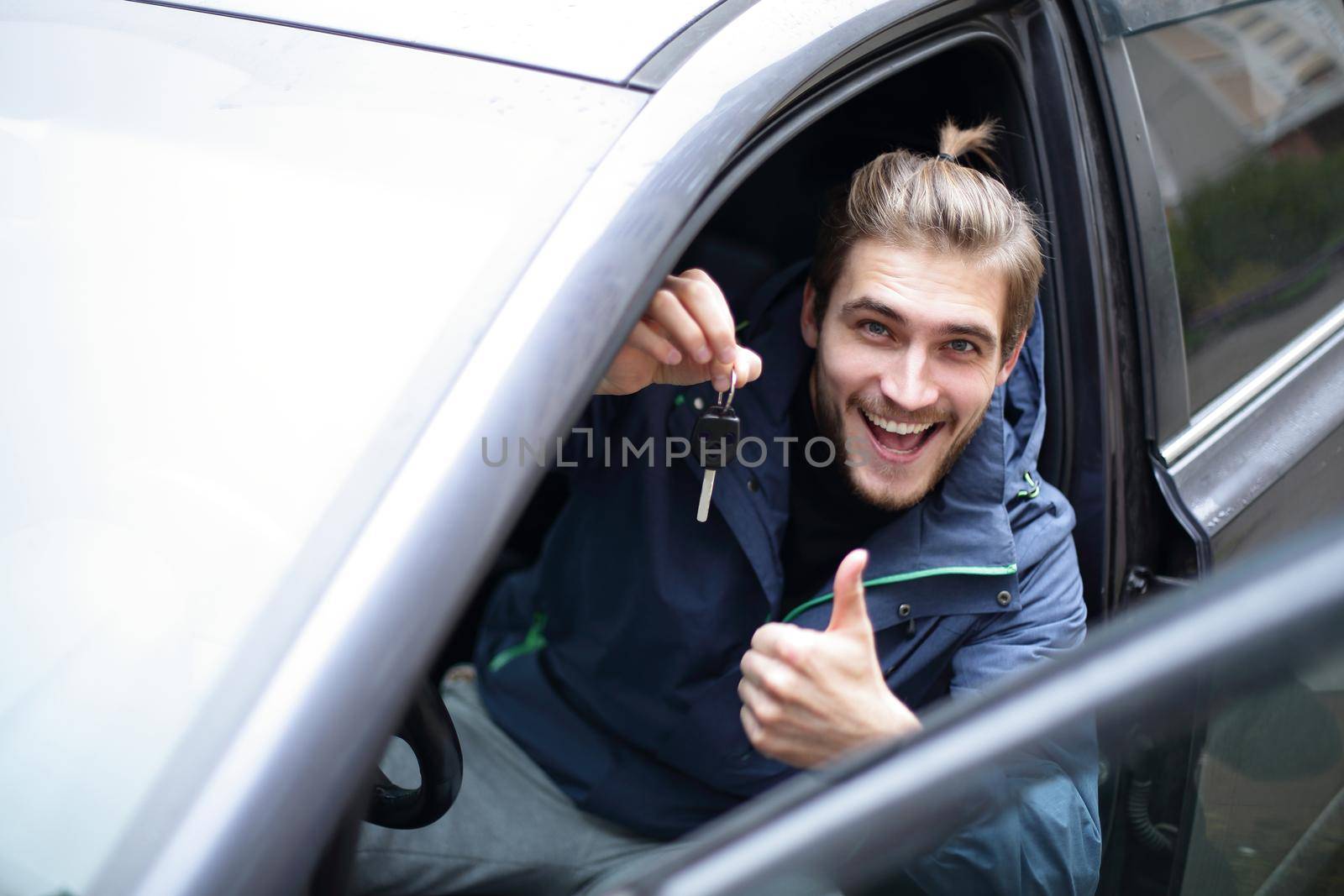 closeup.happy young man in his new car.