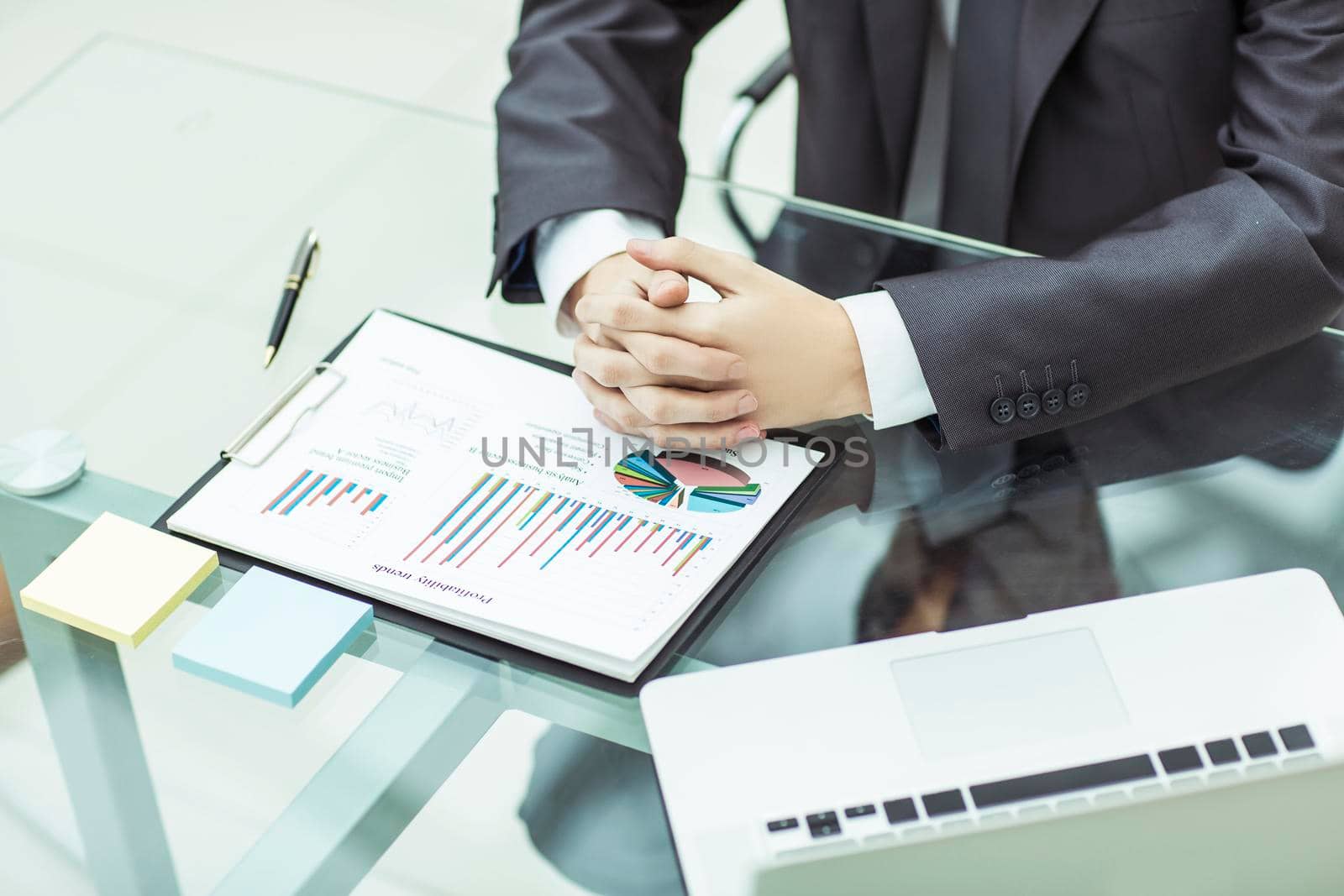 closeup of a businessman ponders the financial policy of the company sitting behind a Desk in the office