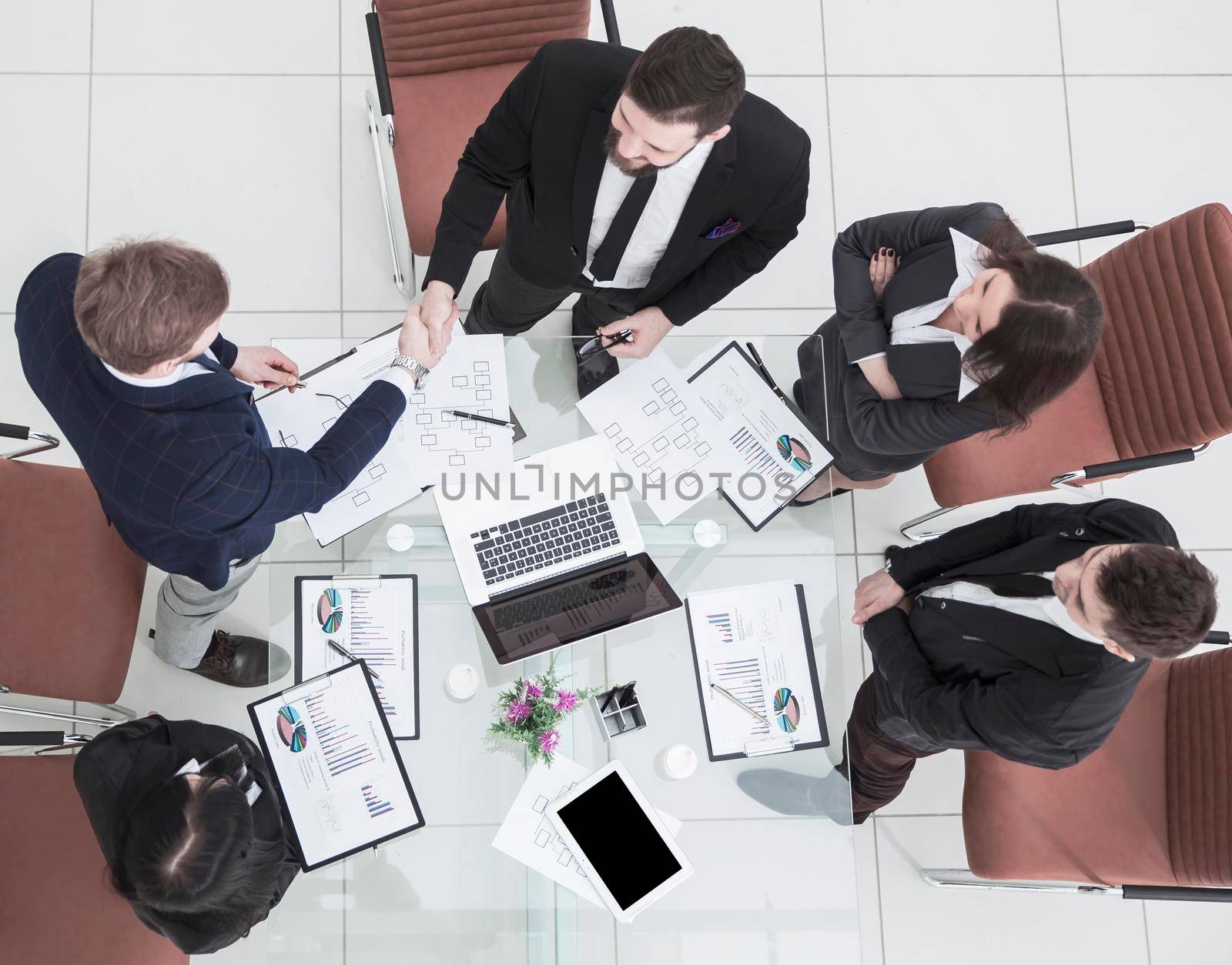 top view - handshake of business partners before the talks near the desktop in a modern office. the photo is a blank space for your text