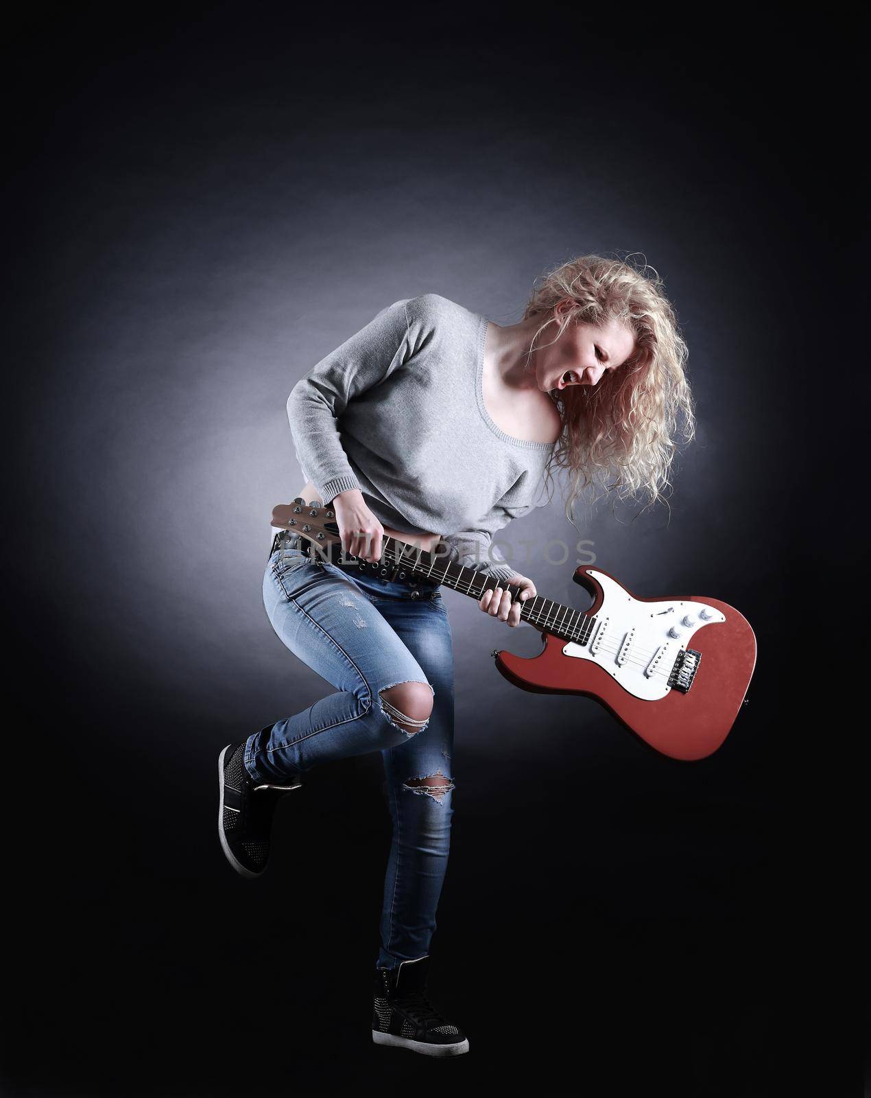 Young and beautiful rock girl playing the electric guitar by SmartPhotoLab
