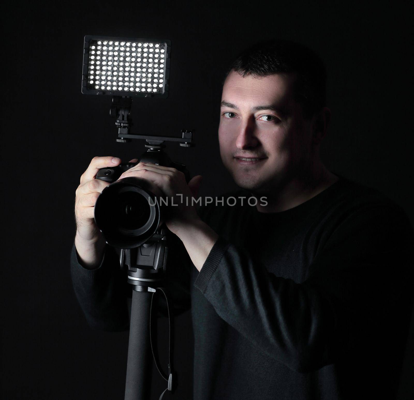 professional photographer with camera on tripod.isolated on black background.