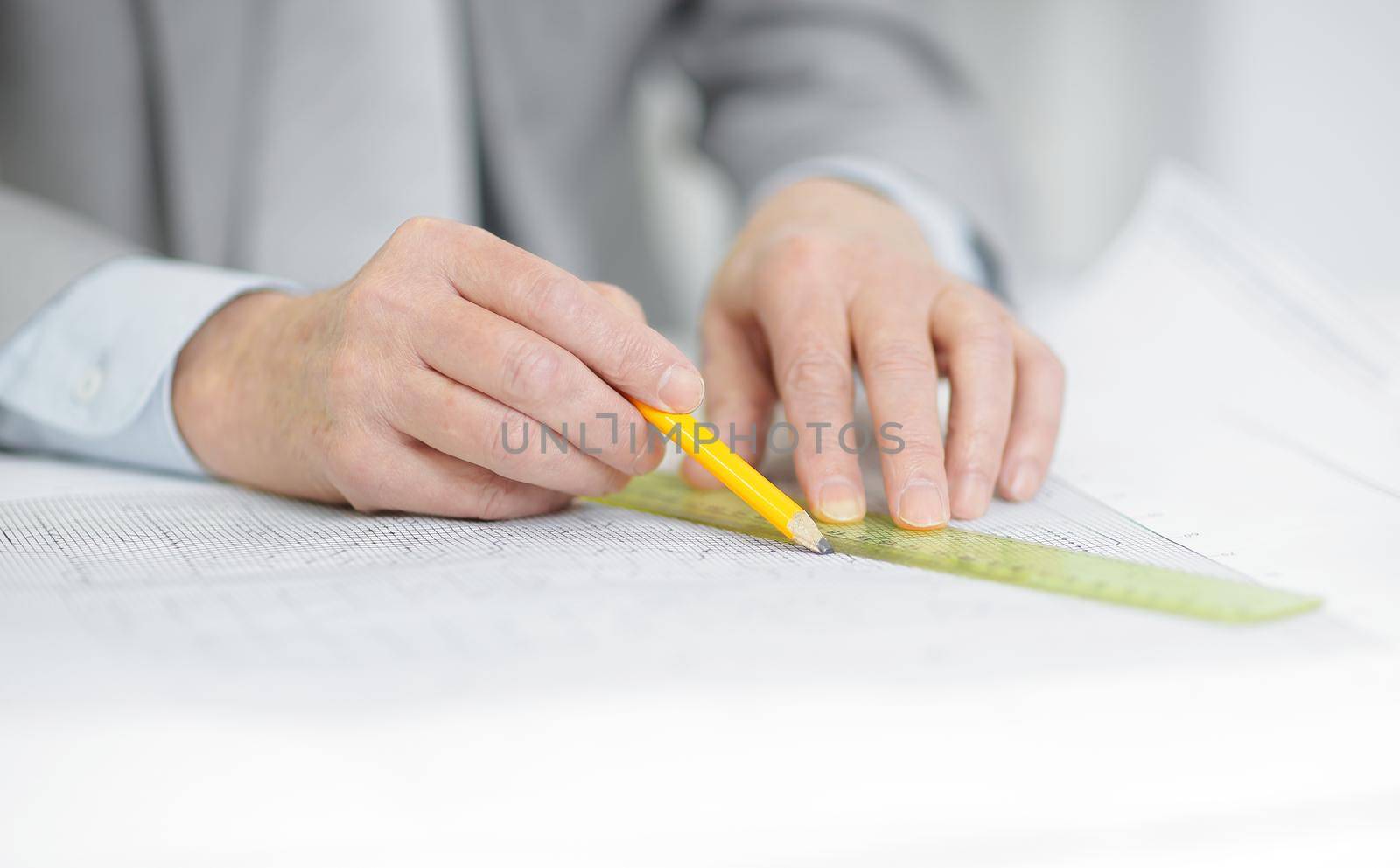 closeup . the engineer is making the drawing sitting behind his Desk by SmartPhotoLab