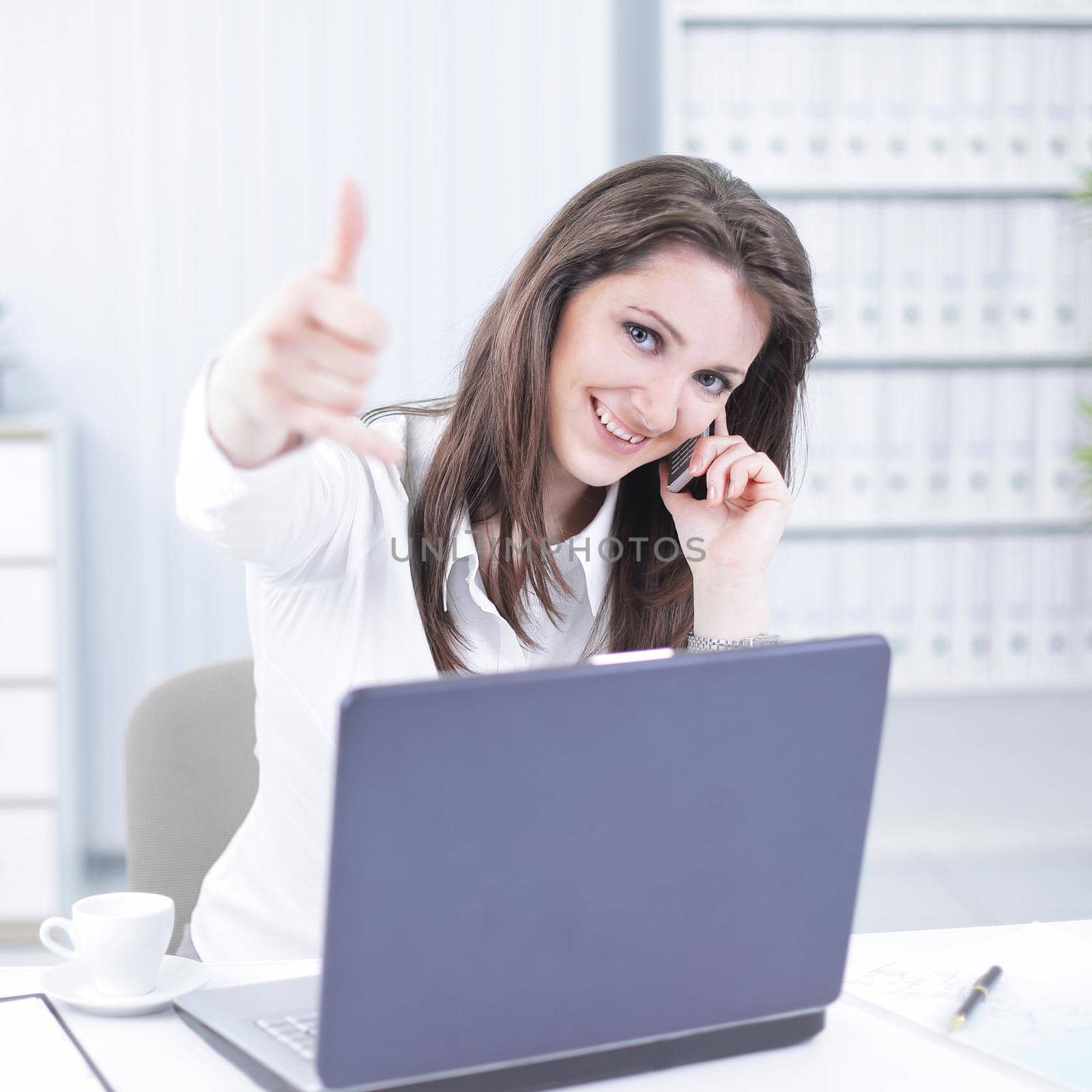 successful business woman showing thumb up in the workplace.photo with copy space