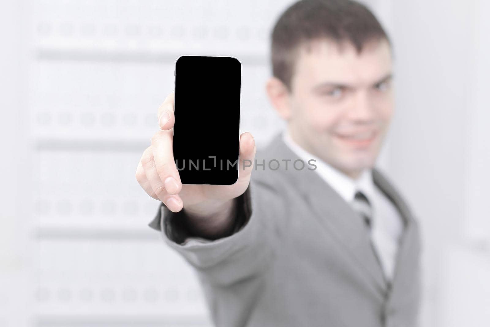 man showing screen of smartphone ,while standing in the office.photo with copy space