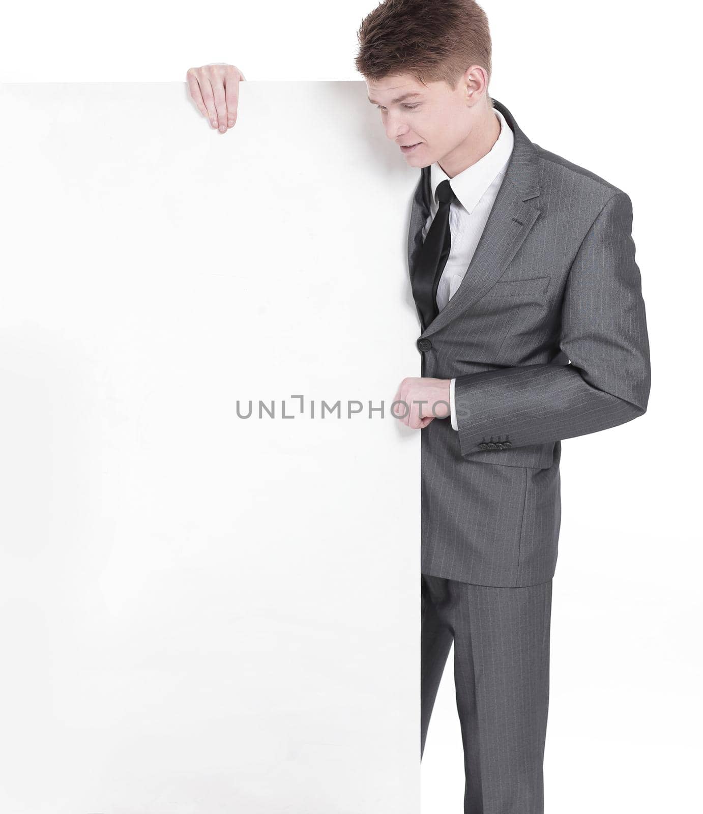 successful young businessman looking at blank banner .isolated on a white