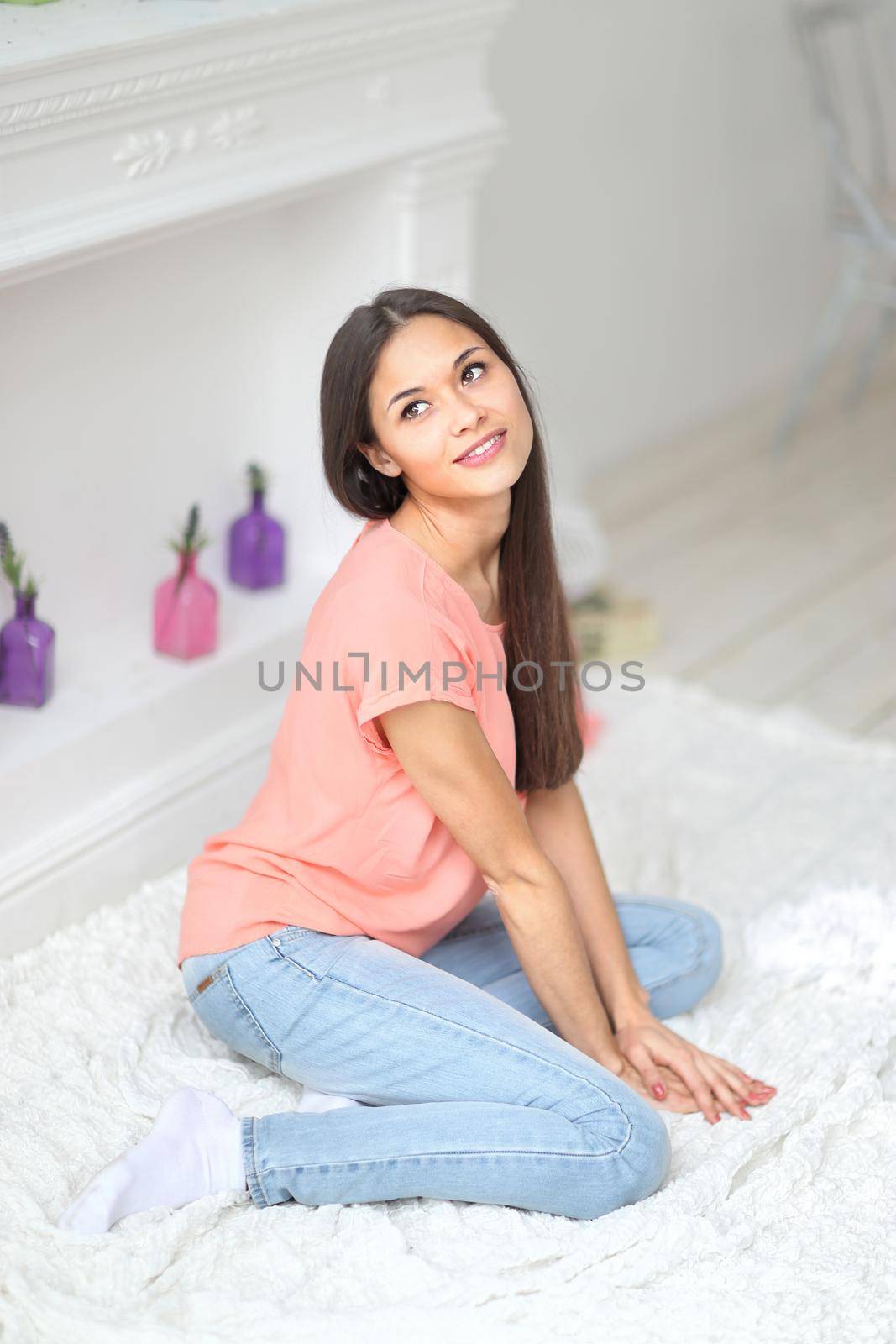 Beautiful brunette woman next to the fireplace and look to the side by SmartPhotoLab