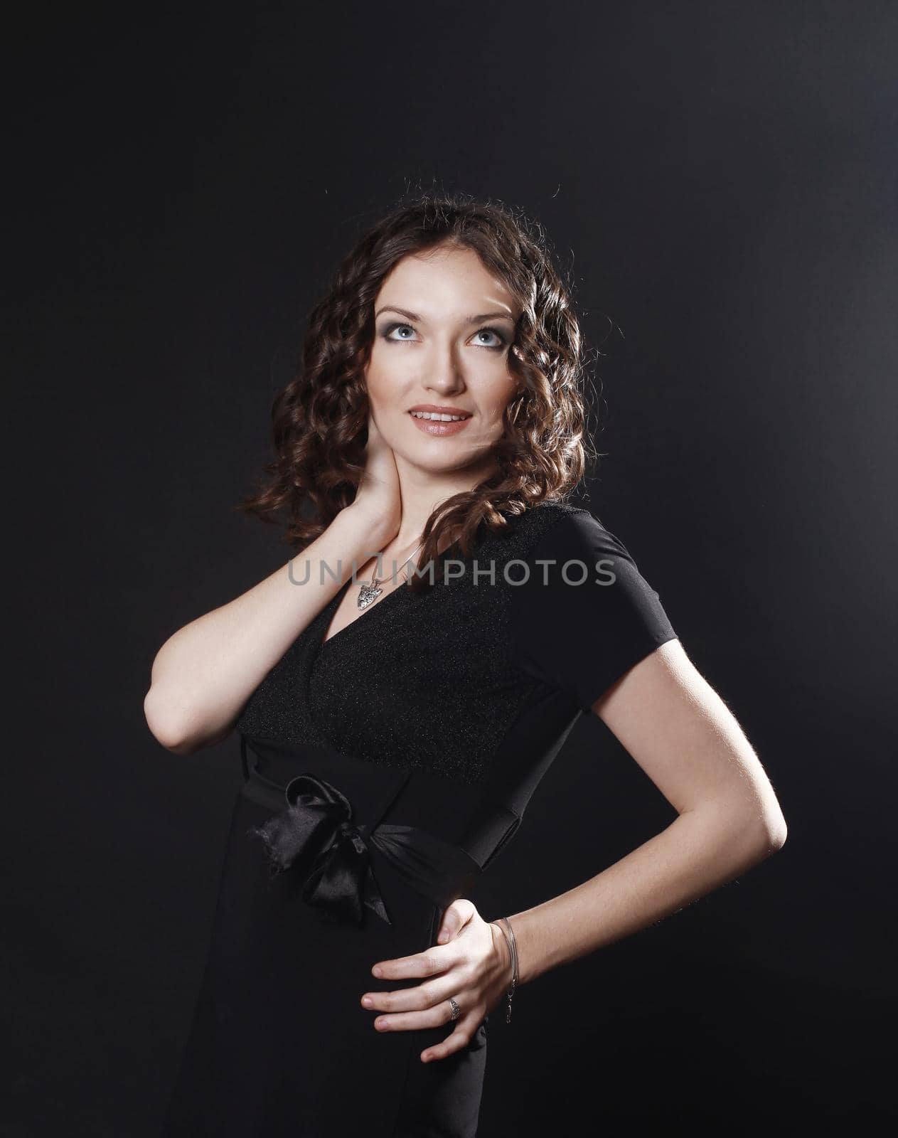 closeup of beautiful young woman in evening black dress.isolated on black background