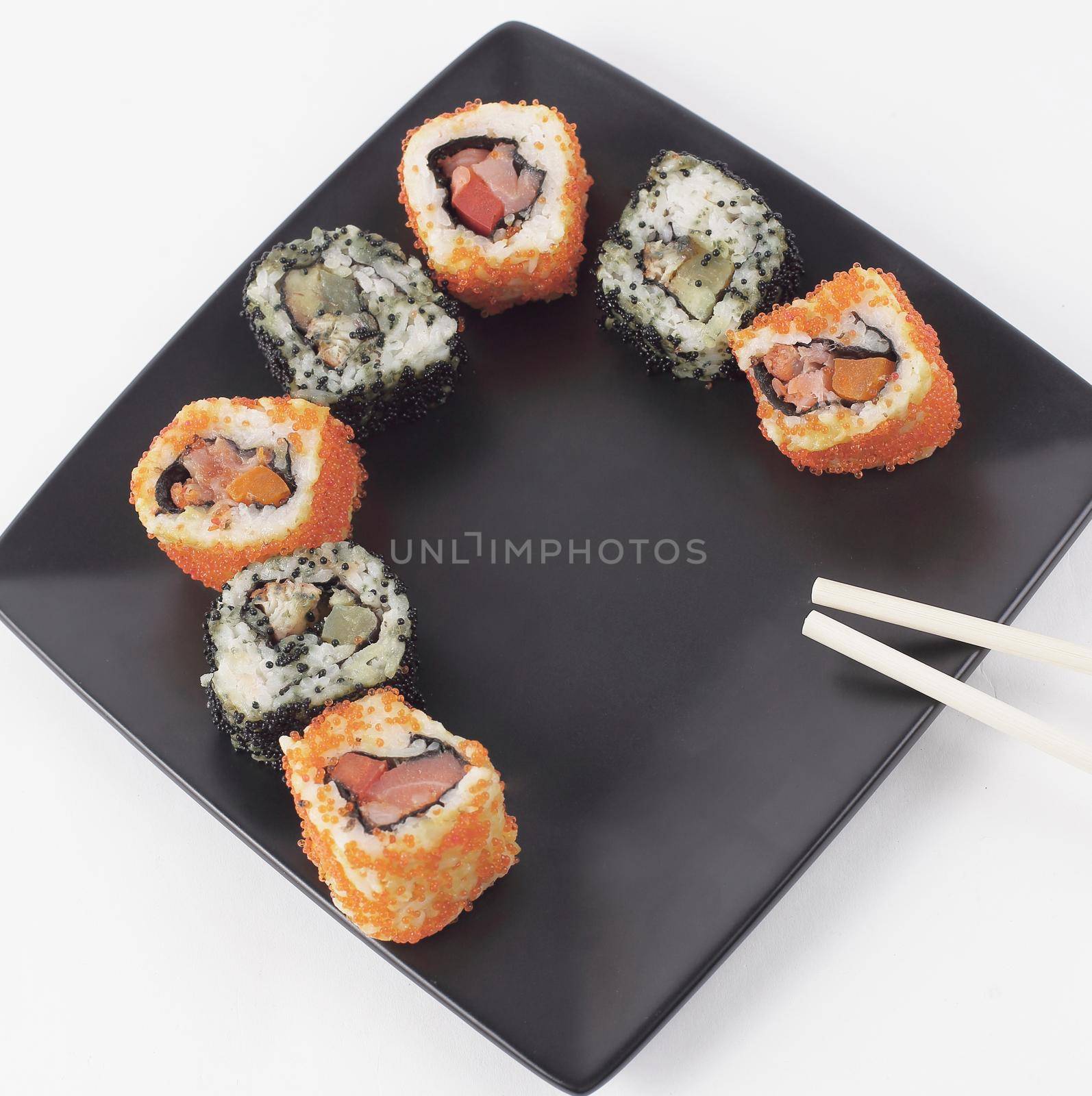 Sushi and rolls. the set is served on a black plate by SmartPhotoLab