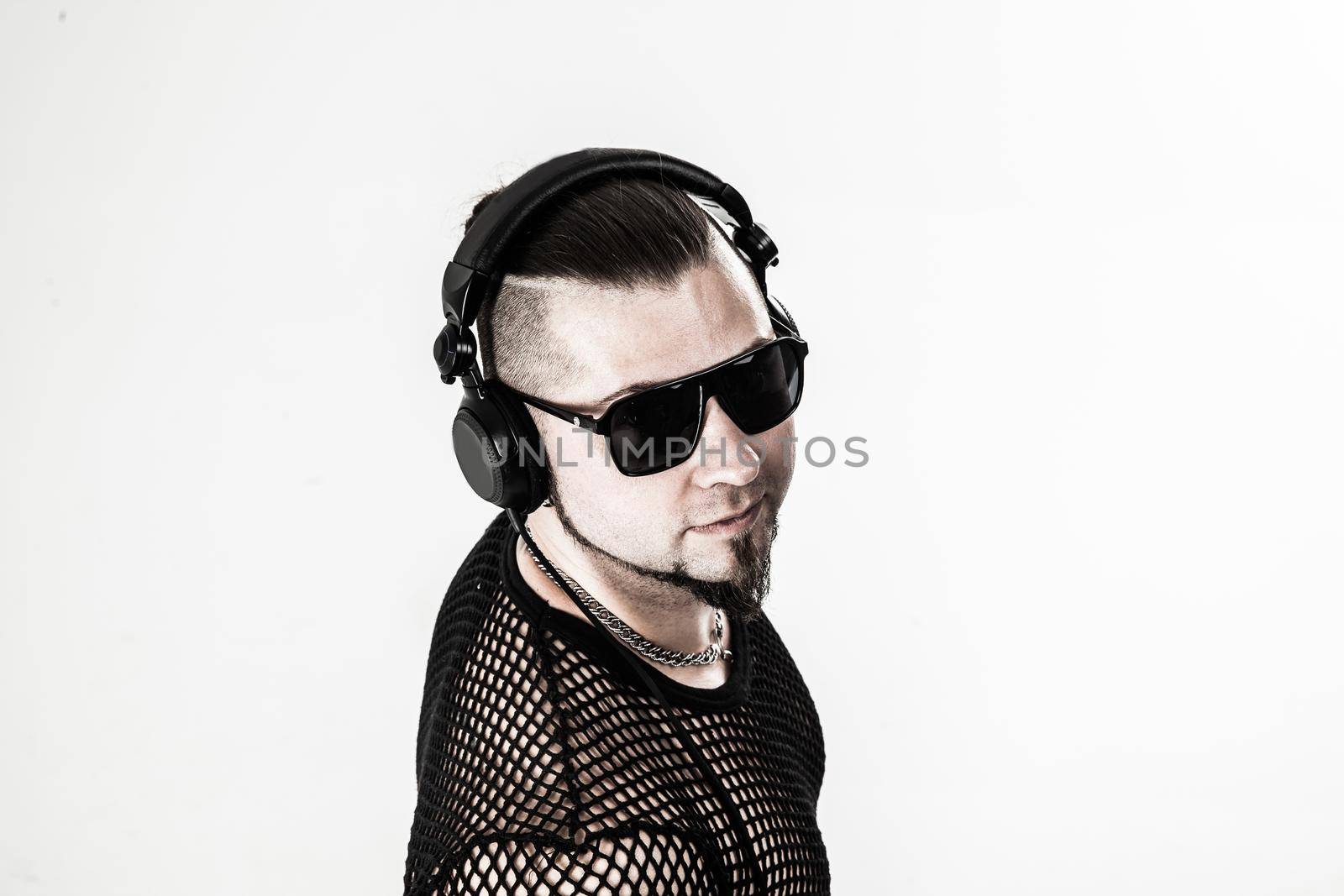 charismatic DJ - rapper with headphones on a light background.the photo has a empty space for your text
