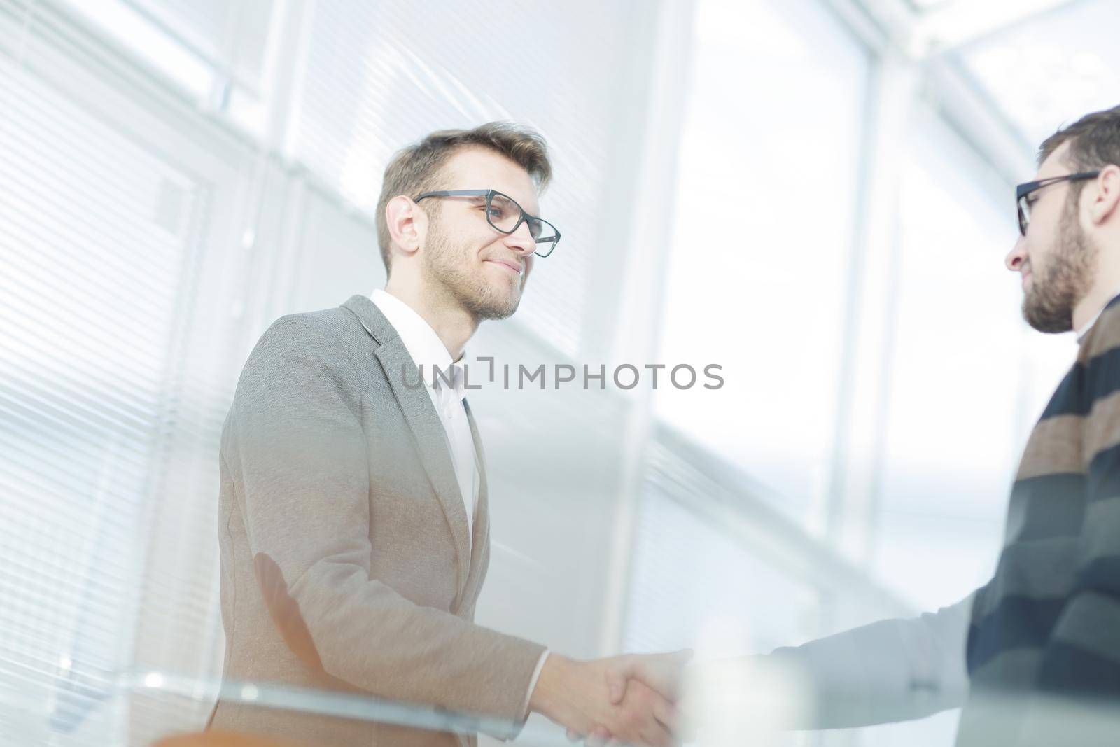 close up.modern young man shaking hand with the Manager. by SmartPhotoLab