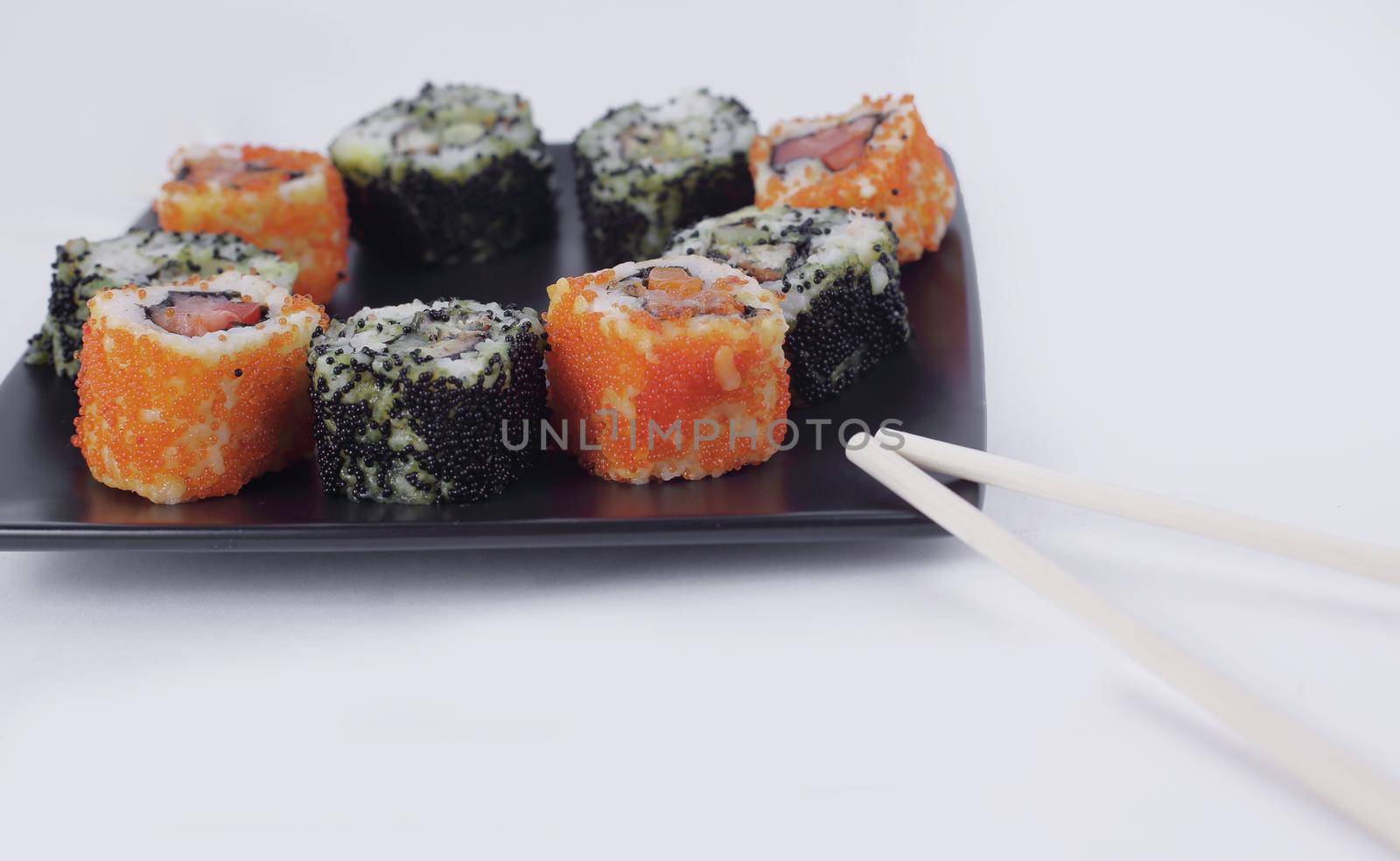 Sushi Set - different types of Maki sushi on a black plate.isolated on white background