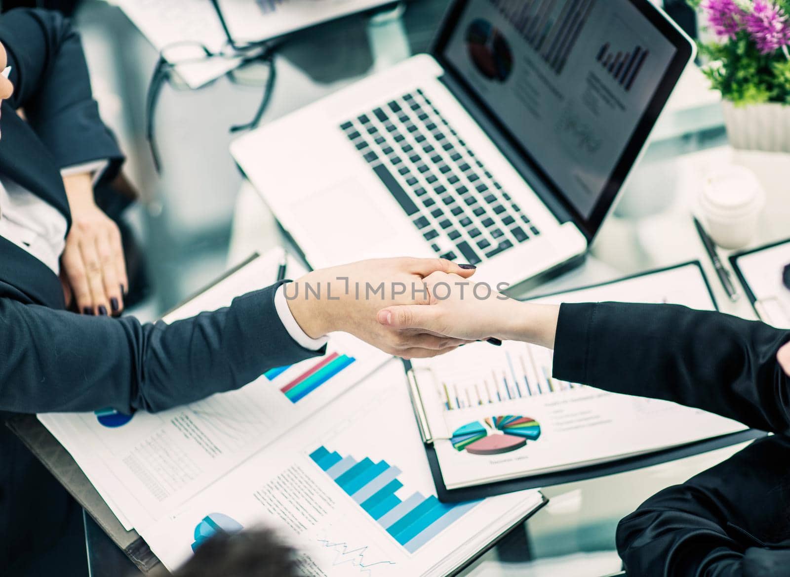 handshake of business partners on the background of the financia by SmartPhotoLab