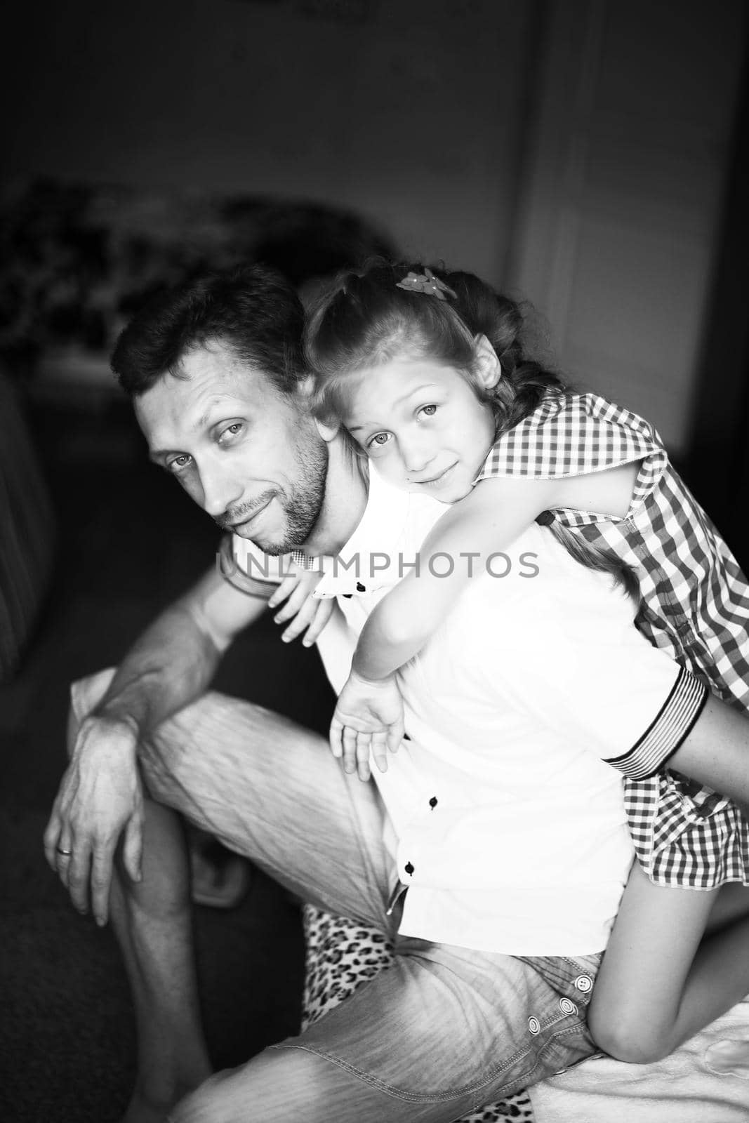black-and-white photo in retro style - a little girl hugging her beloved father .the photograph in the nursery