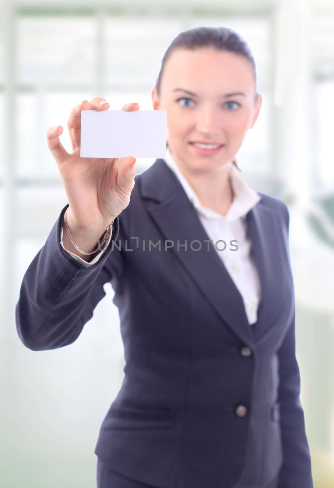 Beautiful businesswoman with the business card in the office by SmartPhotoLab