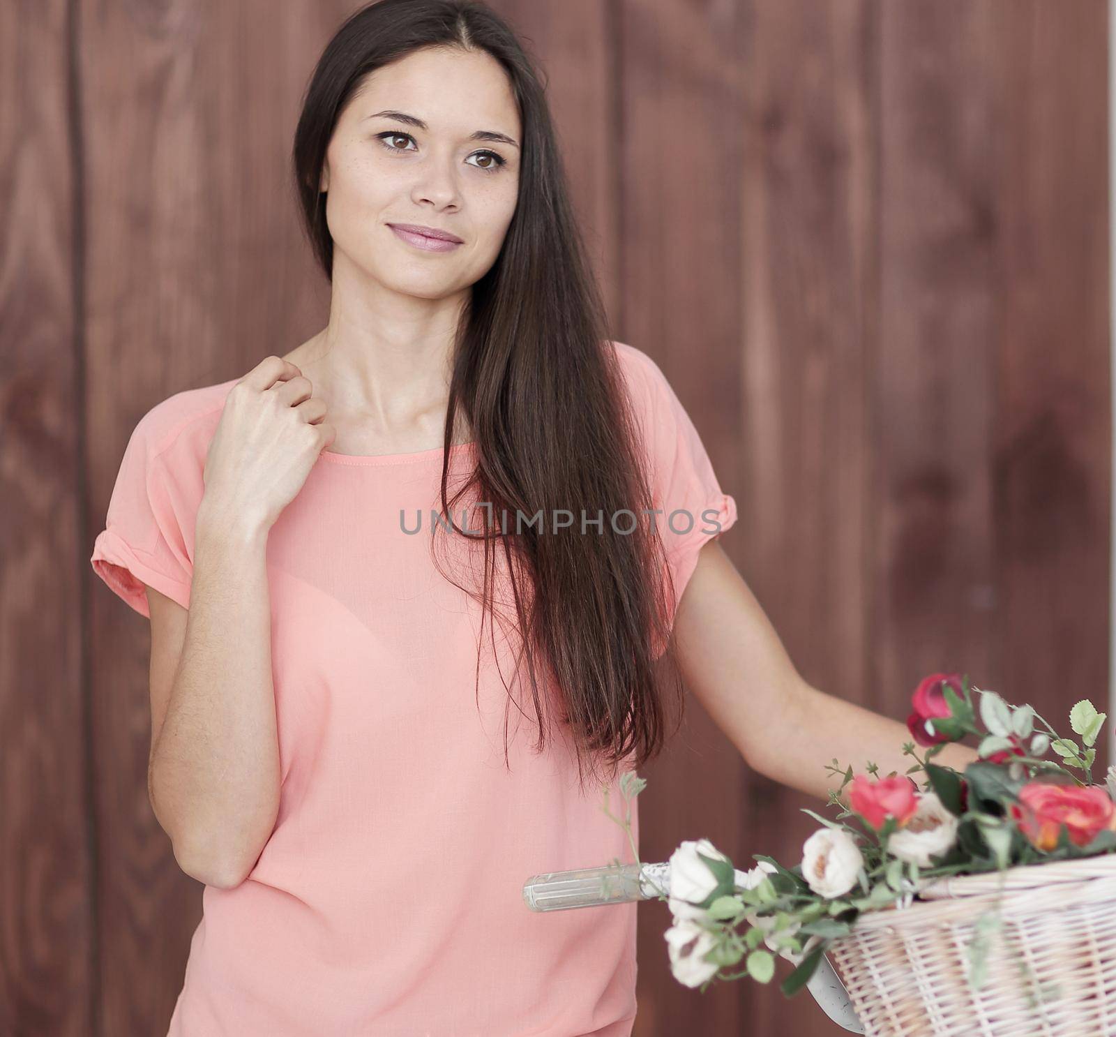 portrait of a young woman with Bicycle and spring flowers in a basket.