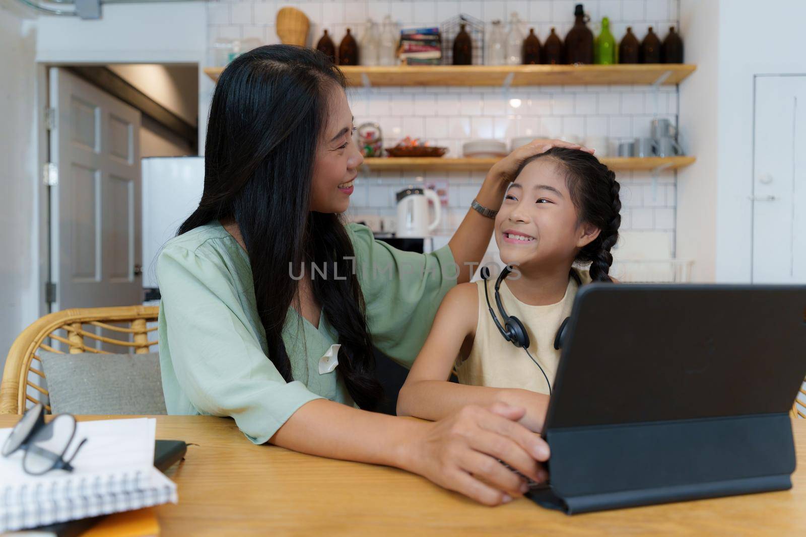 Homeschool Asian mother and little young girl student learning online class. E-learning Online Education concept