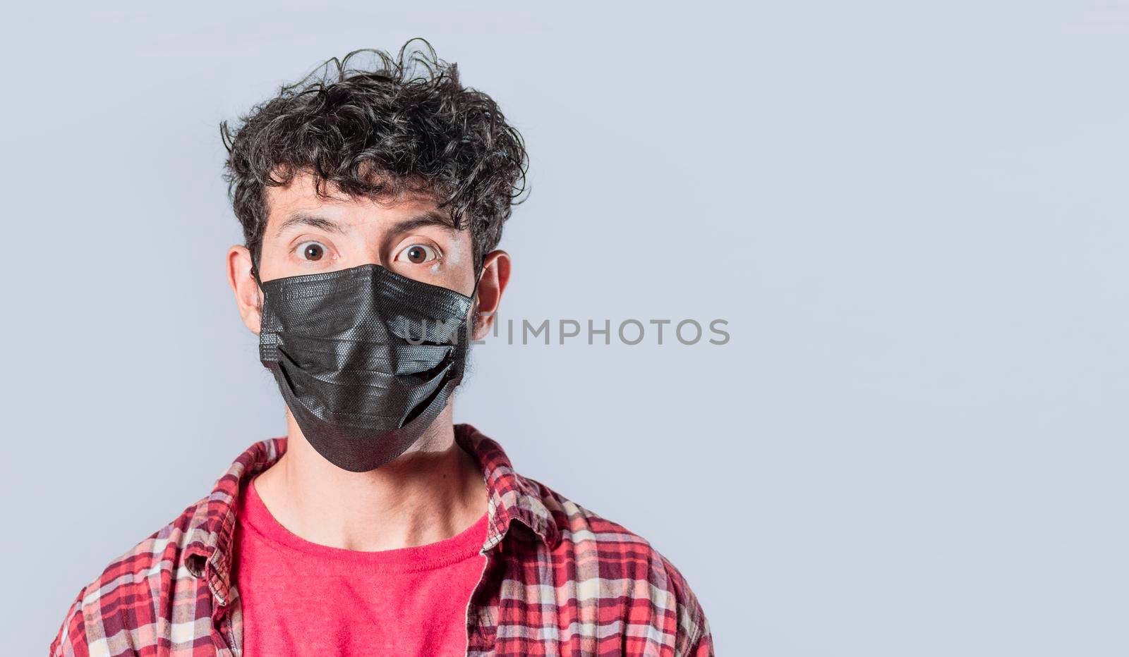 Close up of guy wearing surgical mask on isolated background, close up of handsome guy wearing protective mask by isaiphoto