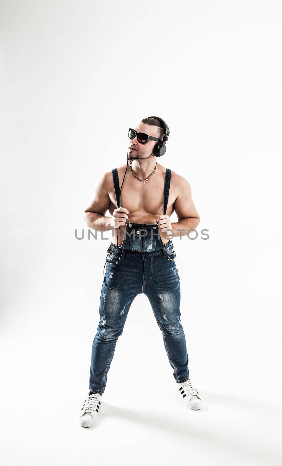 DJ - rapper in a stylish t-shirt with headphones on a white background . the photo has a empty space for your text