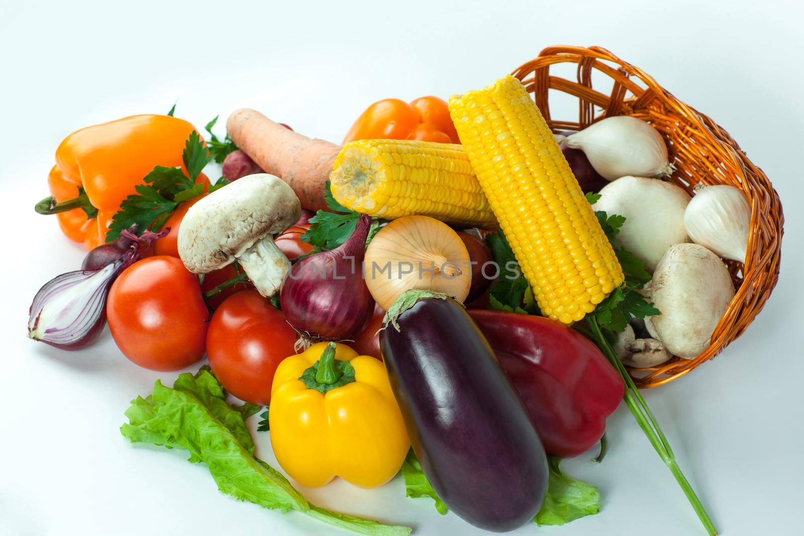 closeup.mushrooms and a variety of fresh vegetables in a wicker basket.isolated on a white background