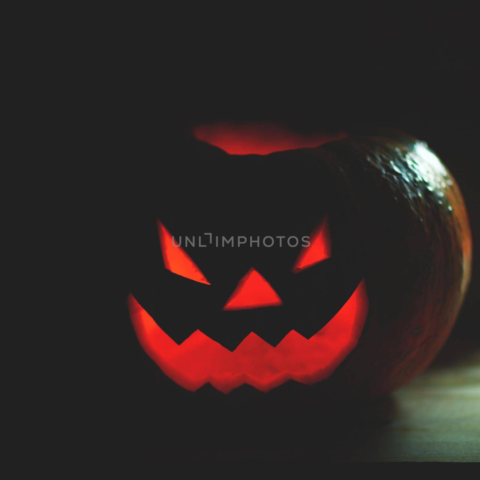 Halloween pumpkin with scary face on black background by SmartPhotoLab