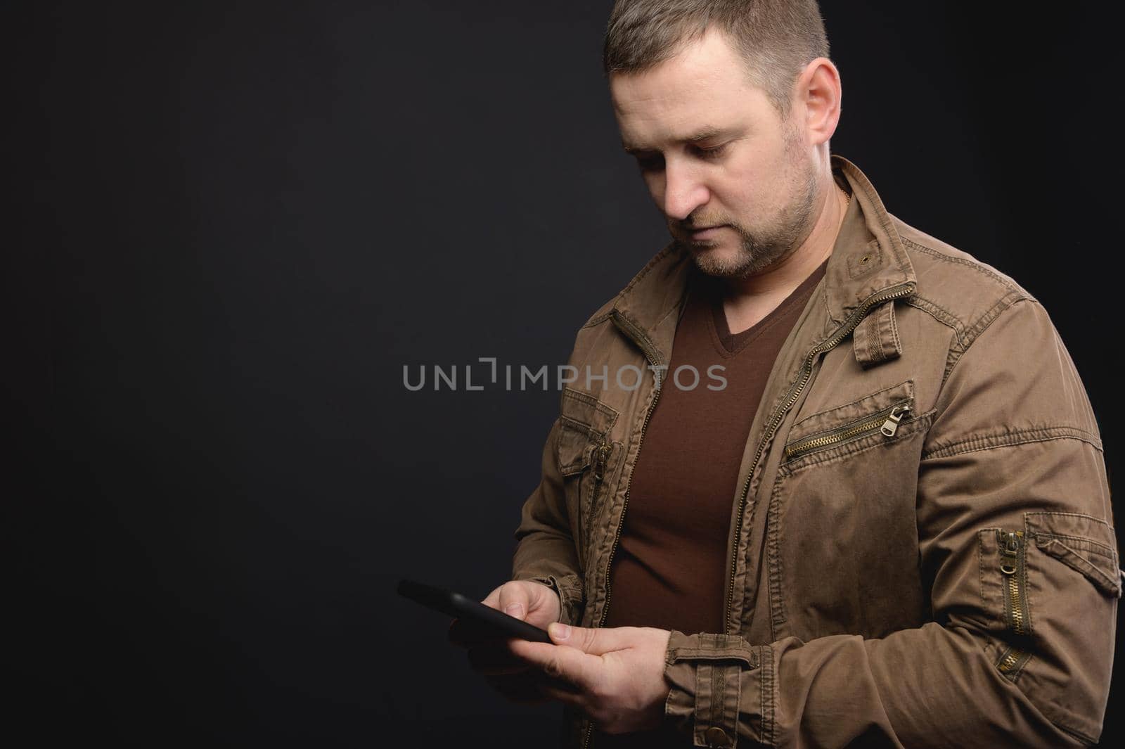 Caucasian male using his smartphone. Typing on the phone. Surfing the internet via a mobile phone.